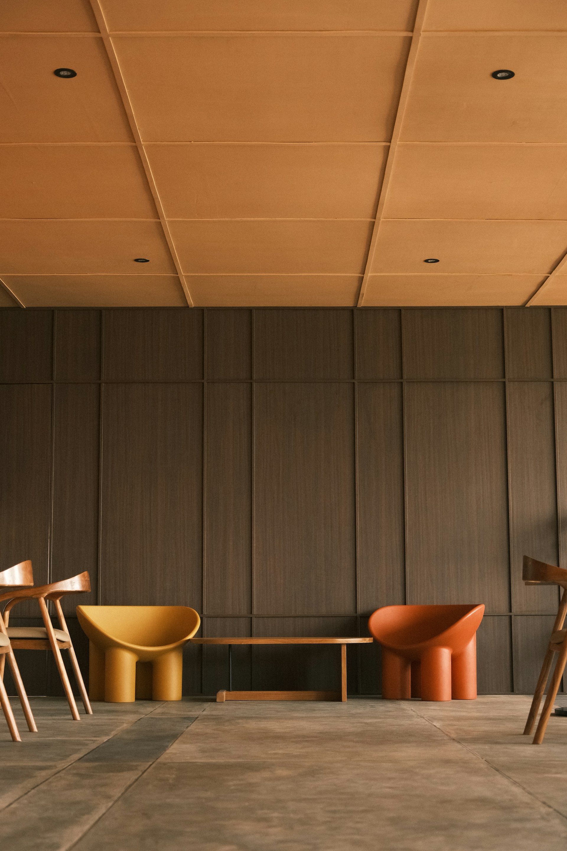 Modern chairs and bench in a room.