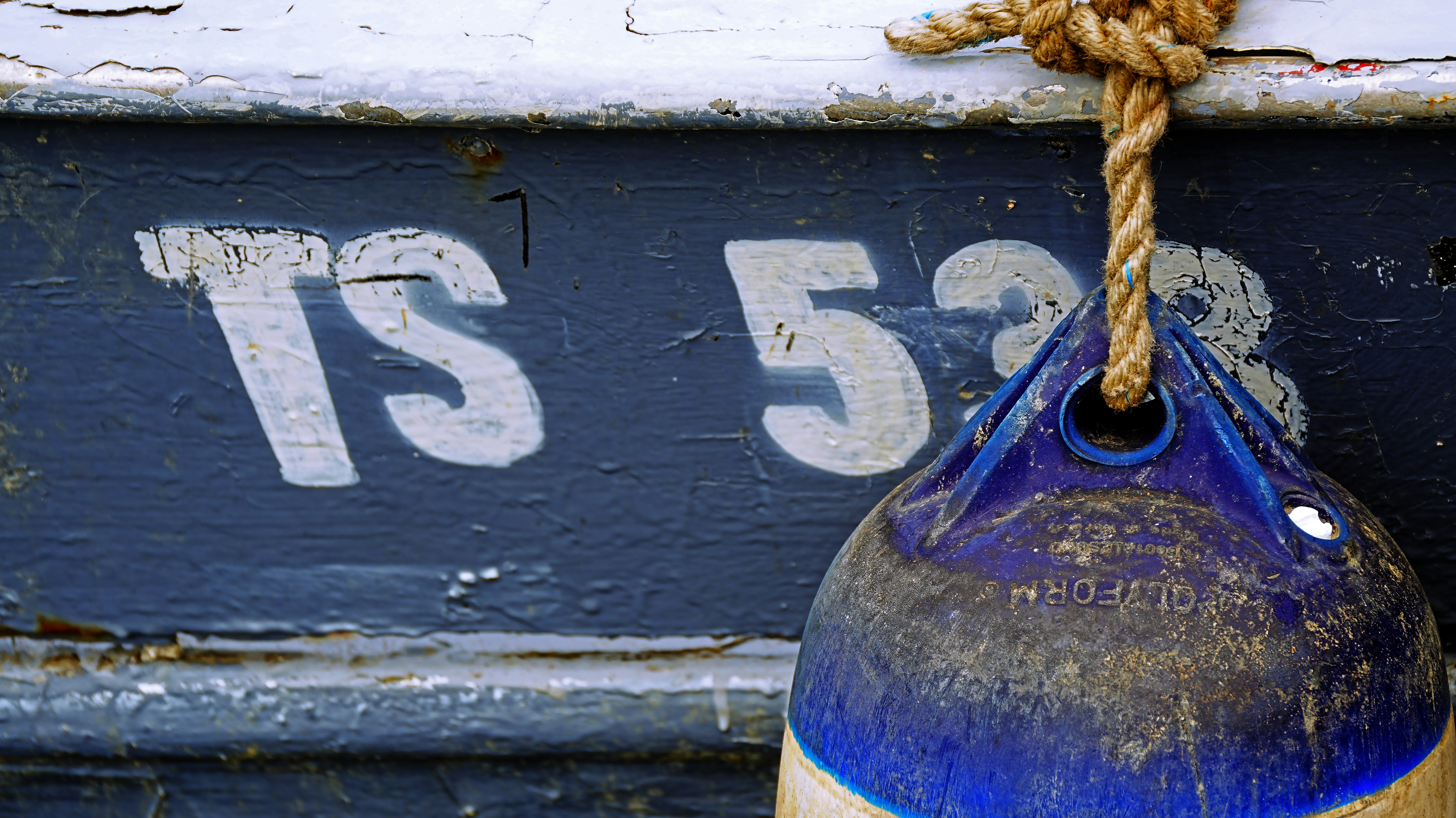 Boat hull with registration ts 523 and buoy.