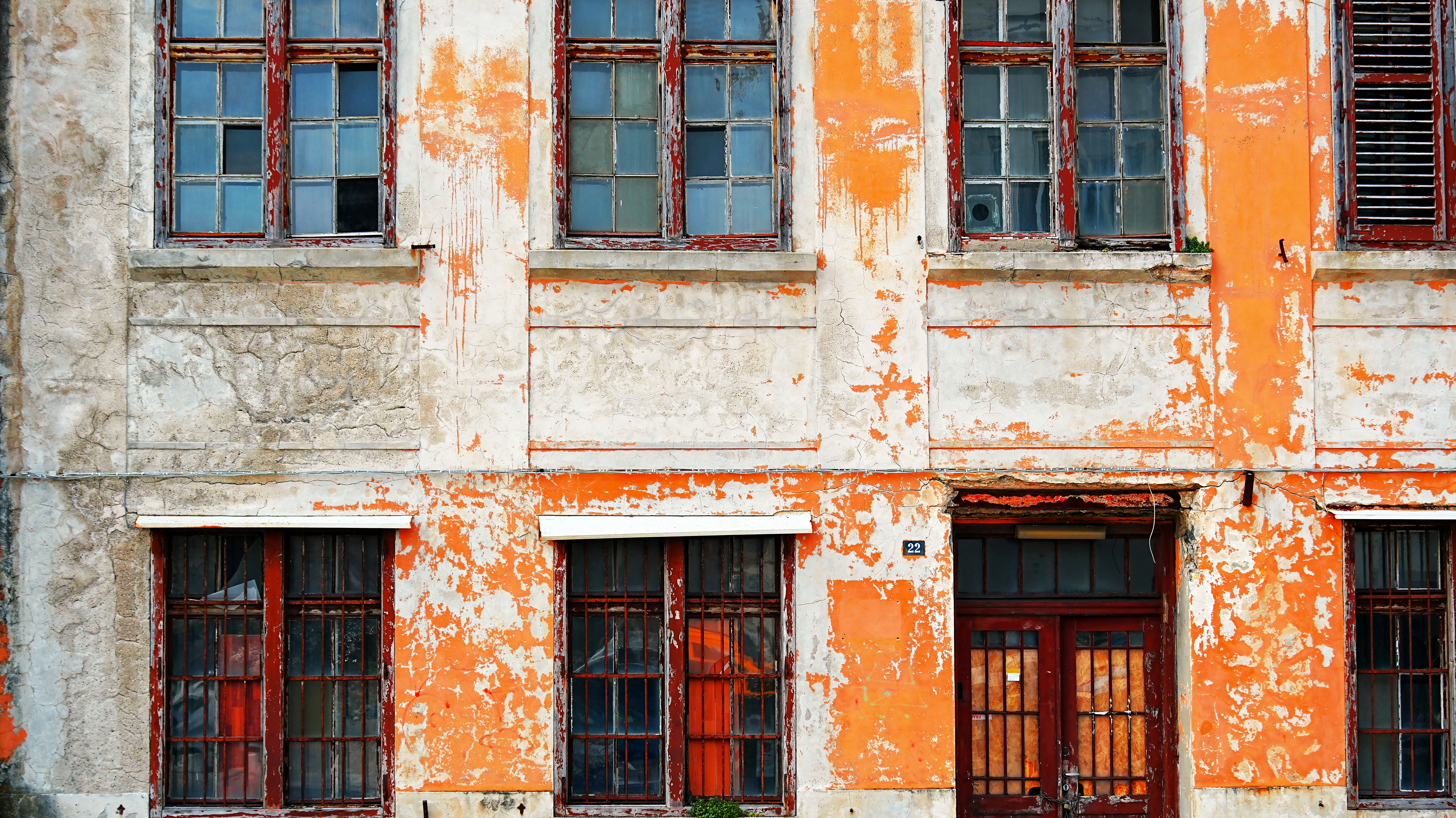 Old building facade with peeling orange paint and broken windows photo –  Free Architecture Image on Unsplash, image size:3000x1686