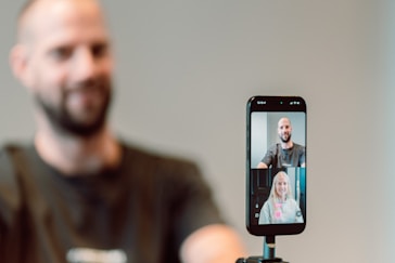 Man video chatting with two people on phone.