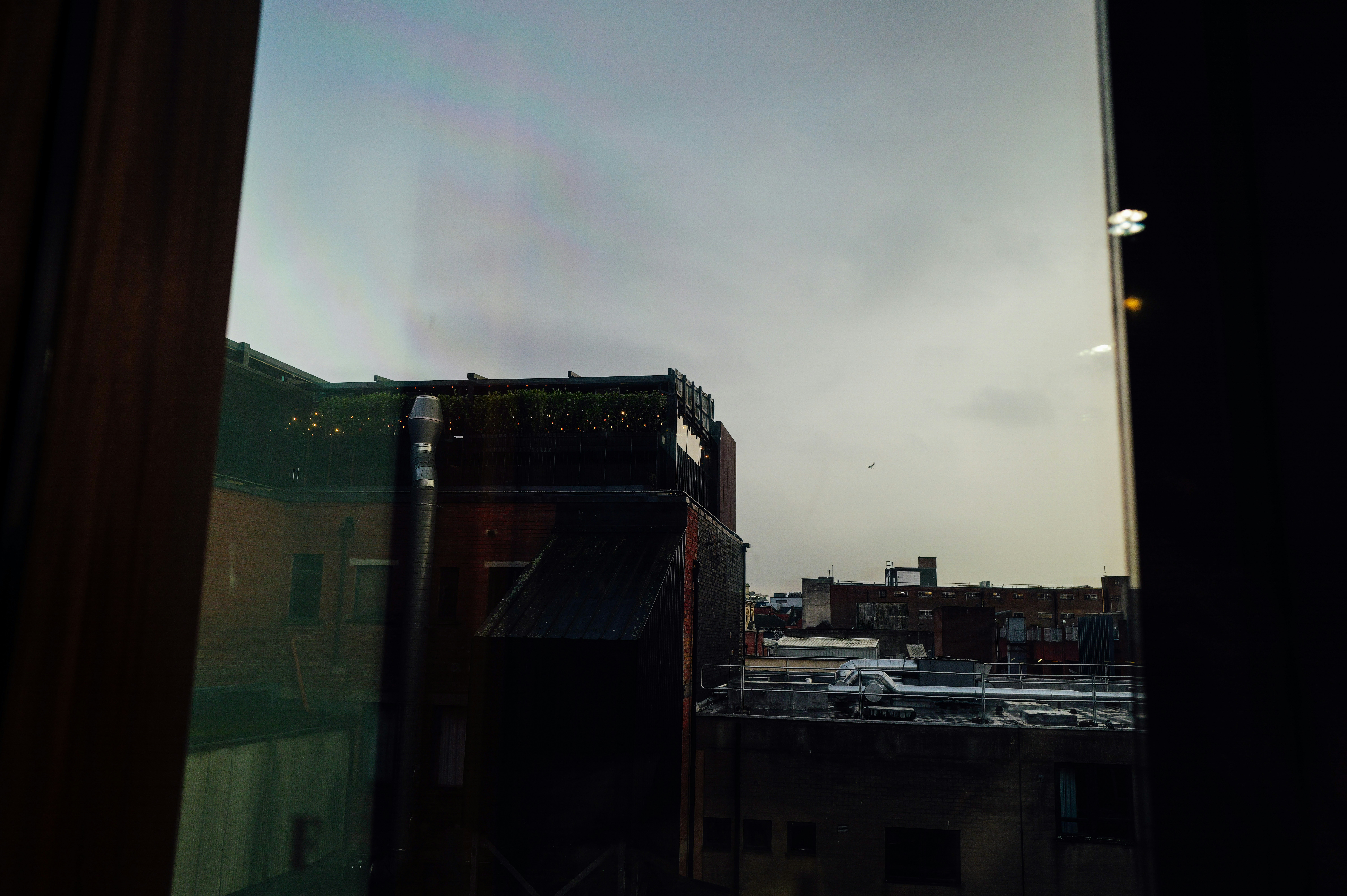 Vista de edificios a través de una ventana al atardecer.