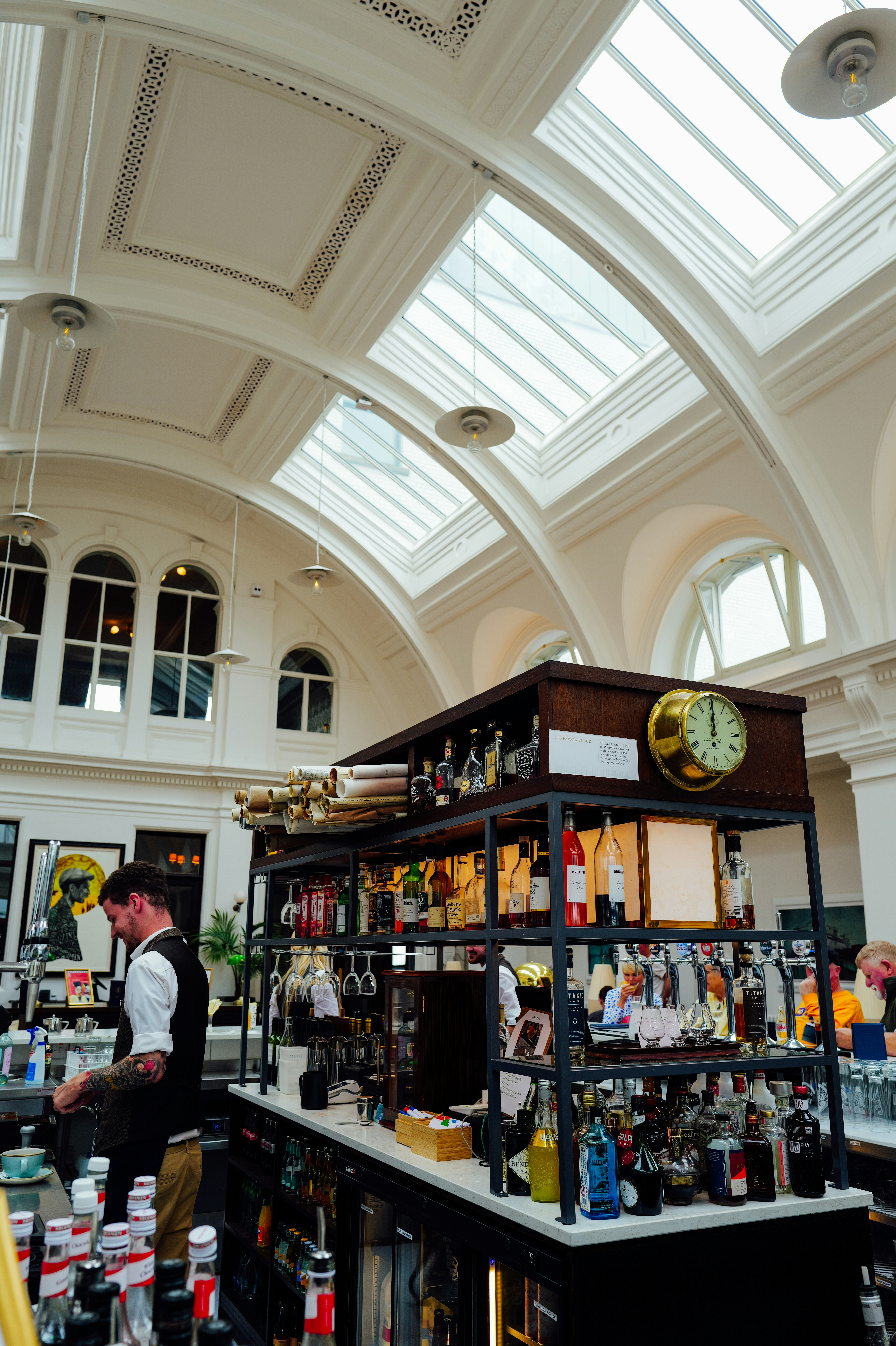 Bartender preparing drinks behind a well-stocked bar.