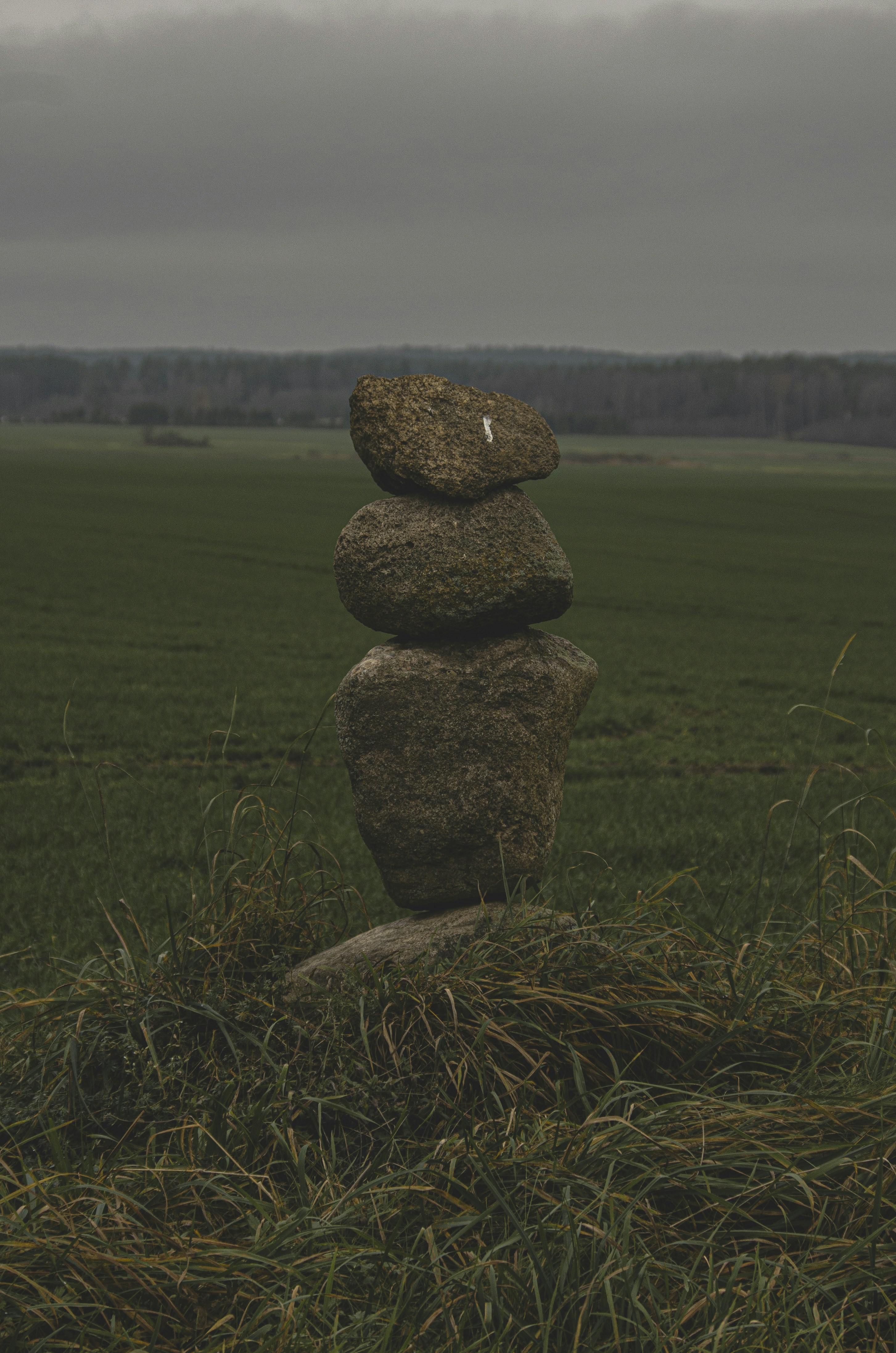 Stack of balanced stones in a grassy field.
