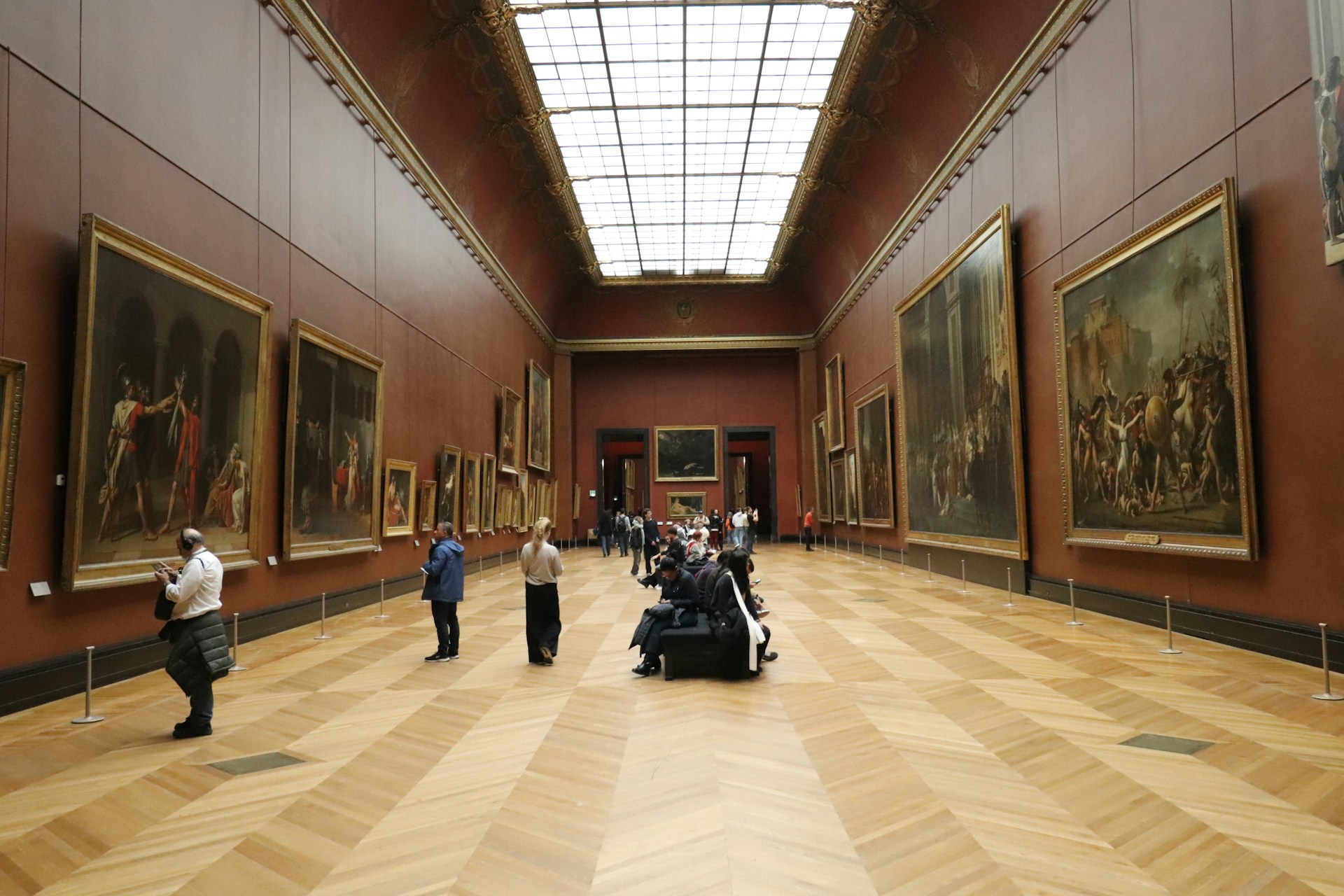 People walking through a grand art museum gallery