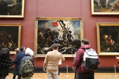 People observe a large painting in a museum gallery.