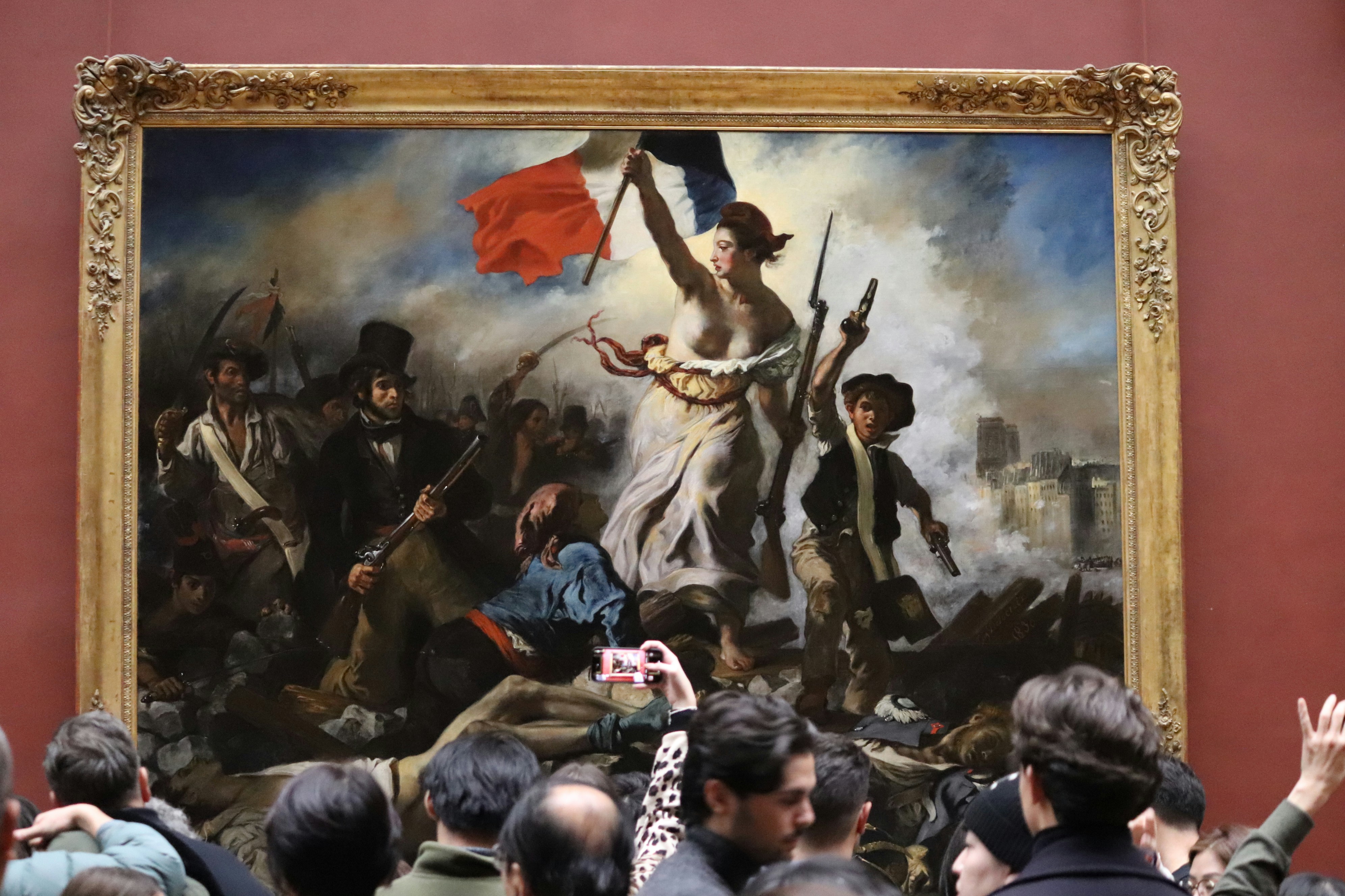 Crowd in front of the painting “Liberty Leading the People” at the Louvre Museum in Paris, France. Work by Eugène Delacroix (1830)