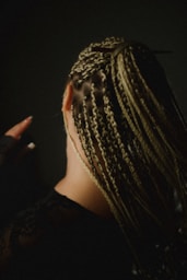 Woman with blonde box braids in dark setting