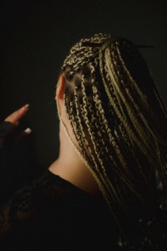 Woman with blonde box braids in dark setting