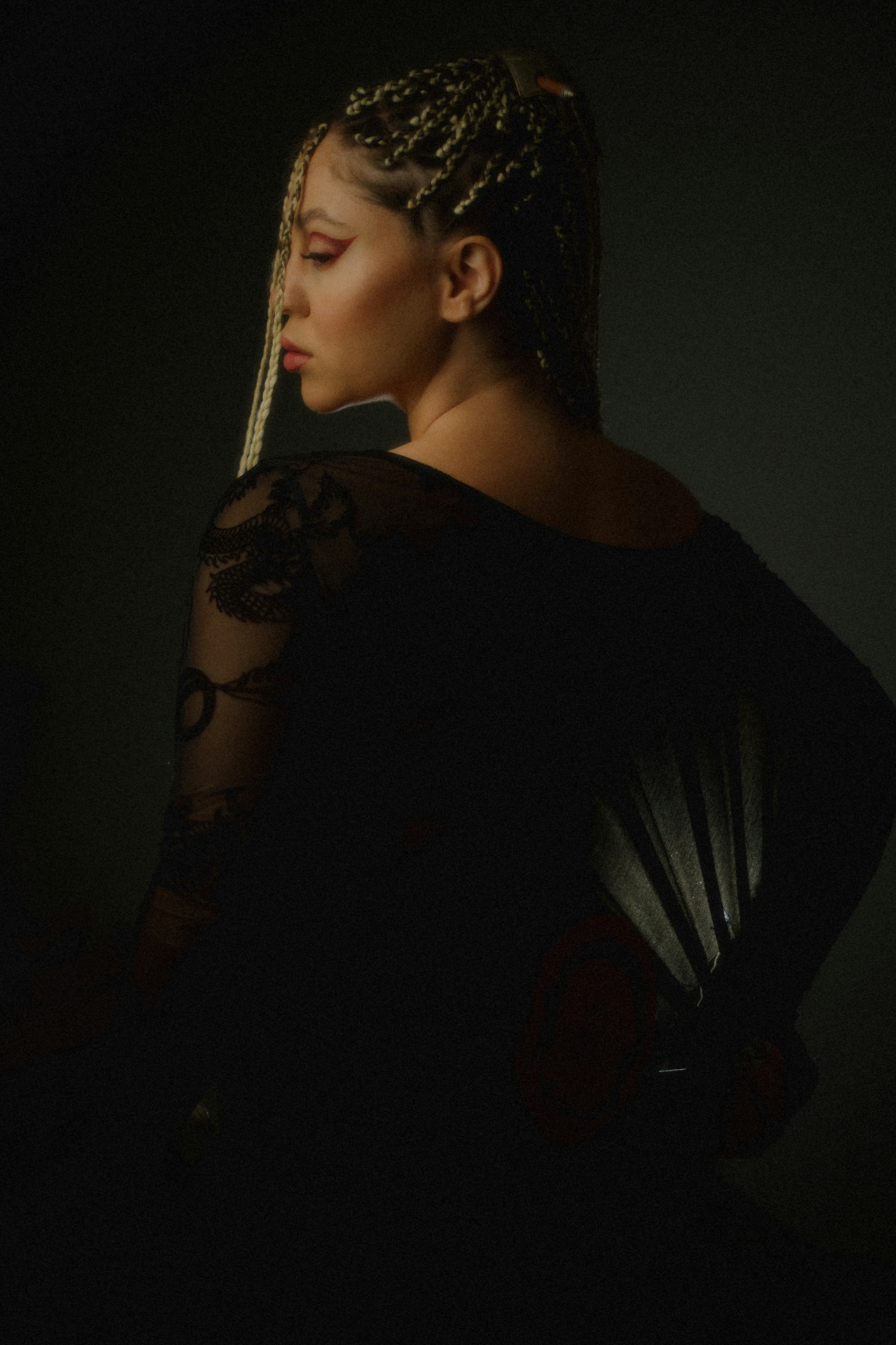 Woman with braided hair holding a fan