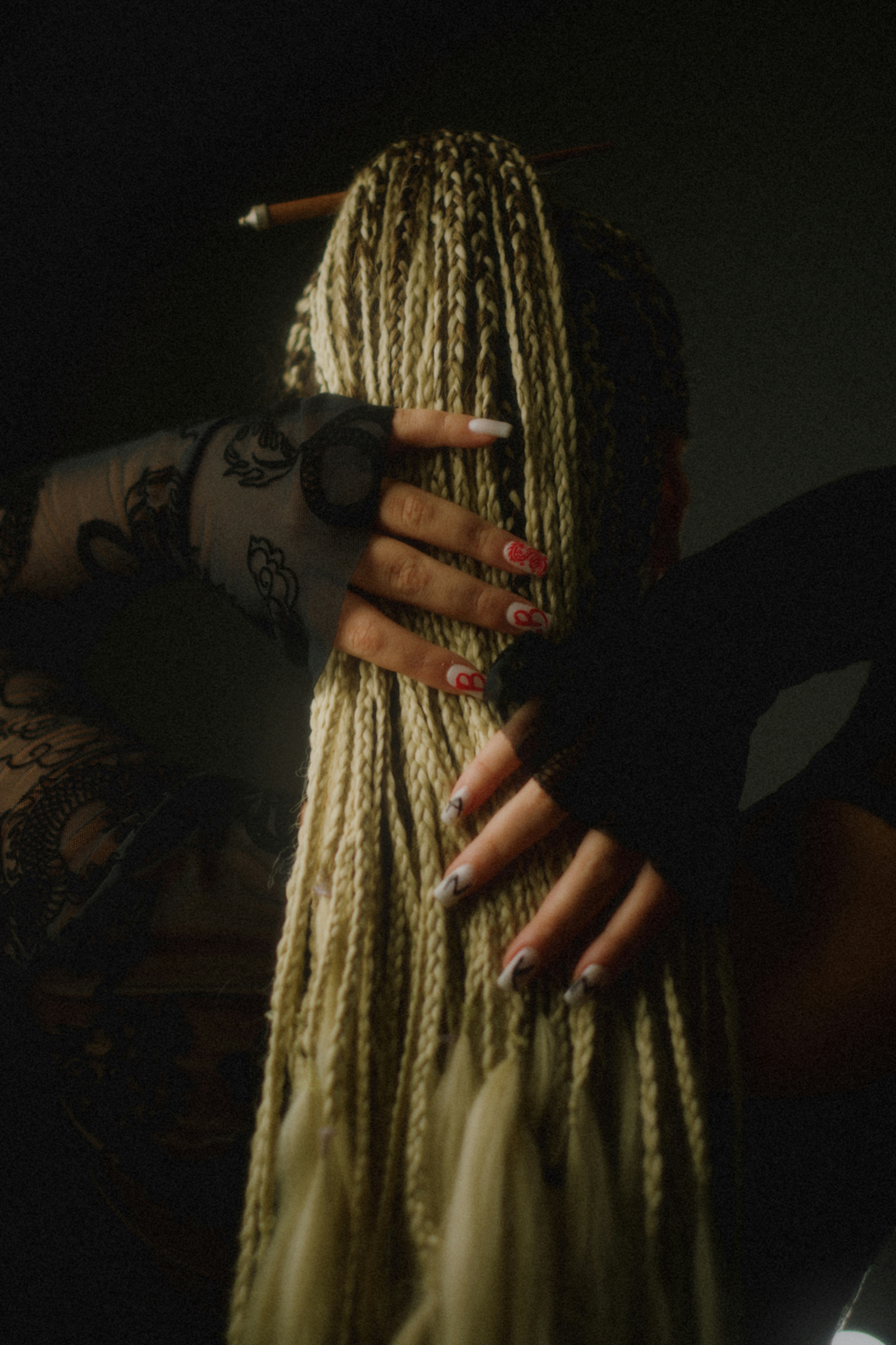 Woman with blonde braids holding her hair