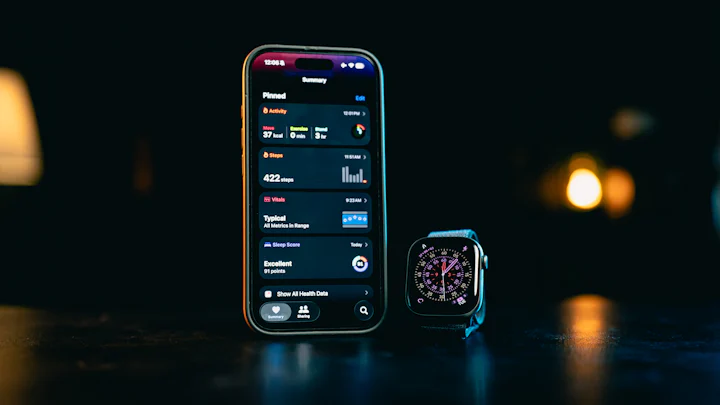 A smartphone showing a fitness summary screen next to a smartwatch on a dark table