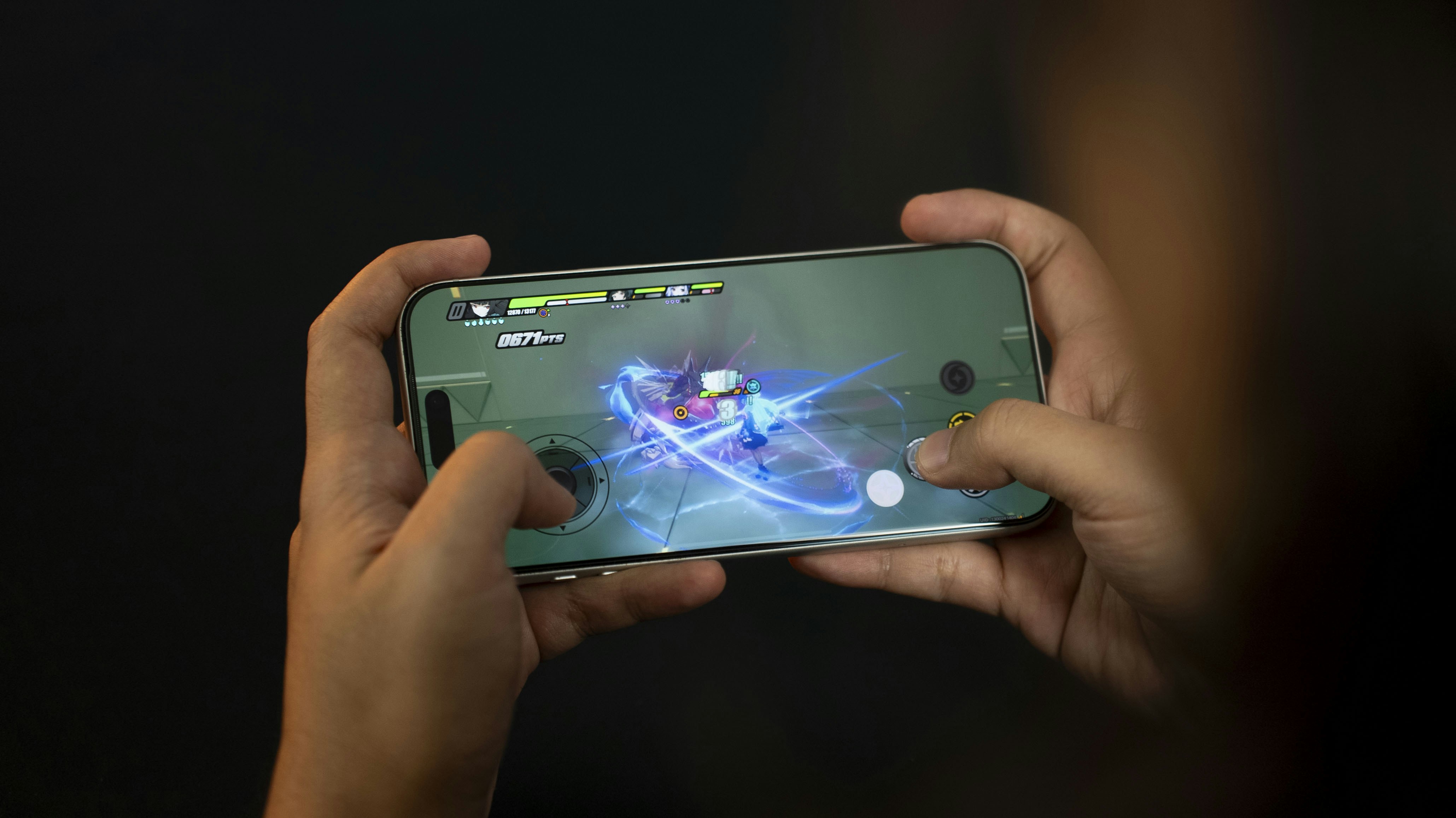 Manos sosteniendo un teléfono inteligente jugando un videojuego.