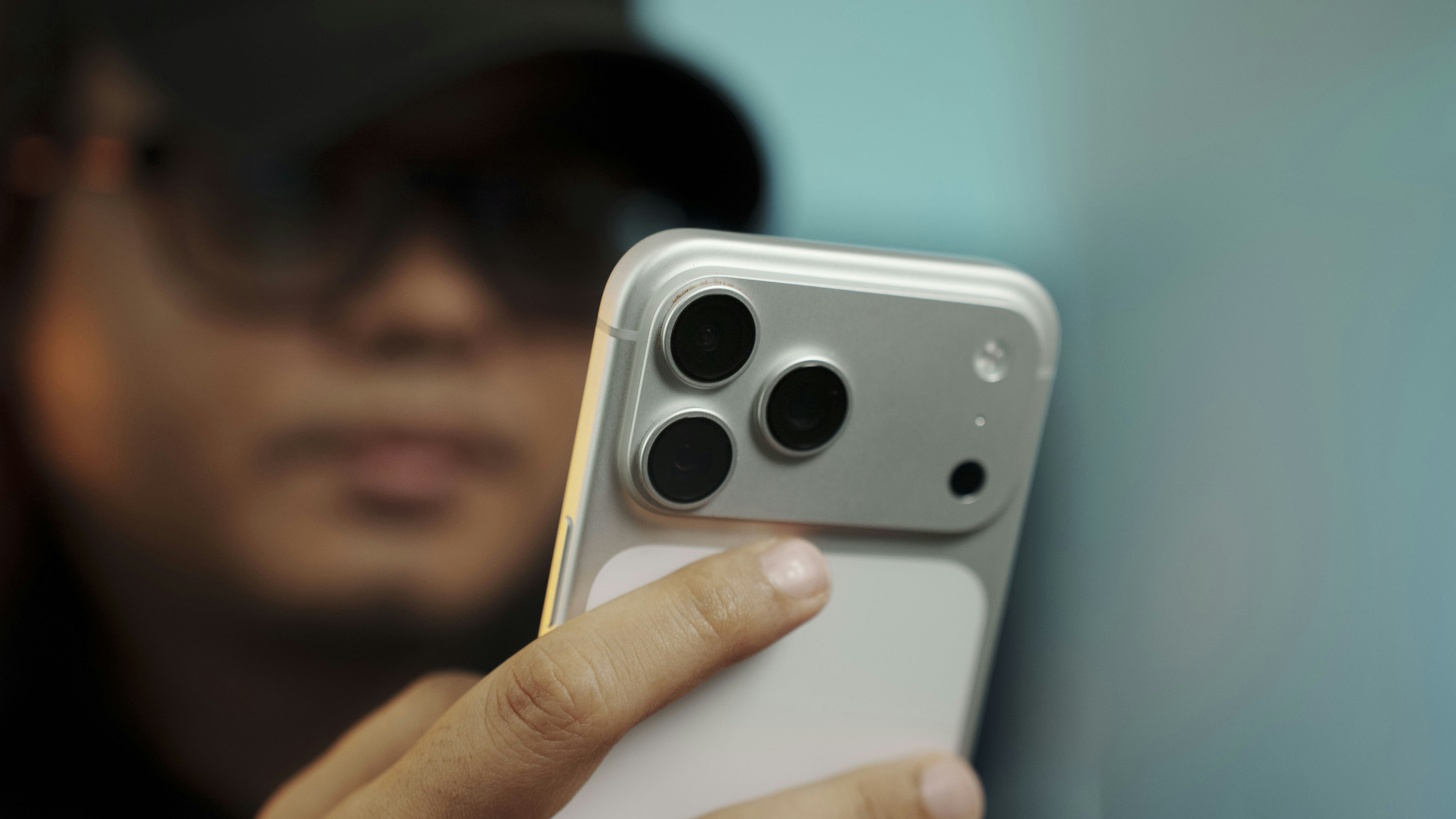 Person holding a modern smartphone with multiple cameras.