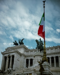 Italian flag flies over monument with equestrian statues
