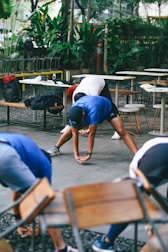 Group stretching outdoors near tables and chairs