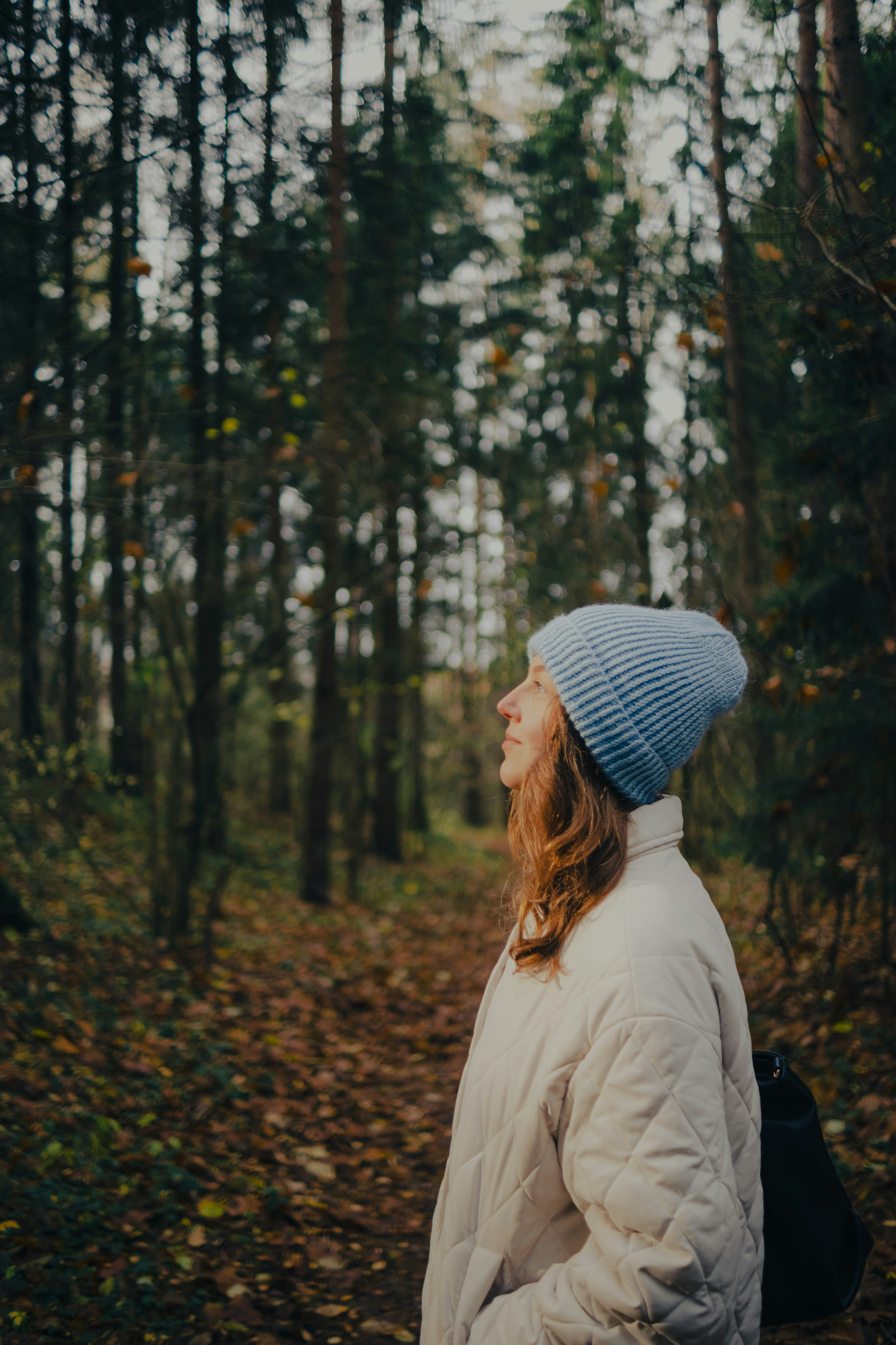 Woman in blue hat in autumn forest