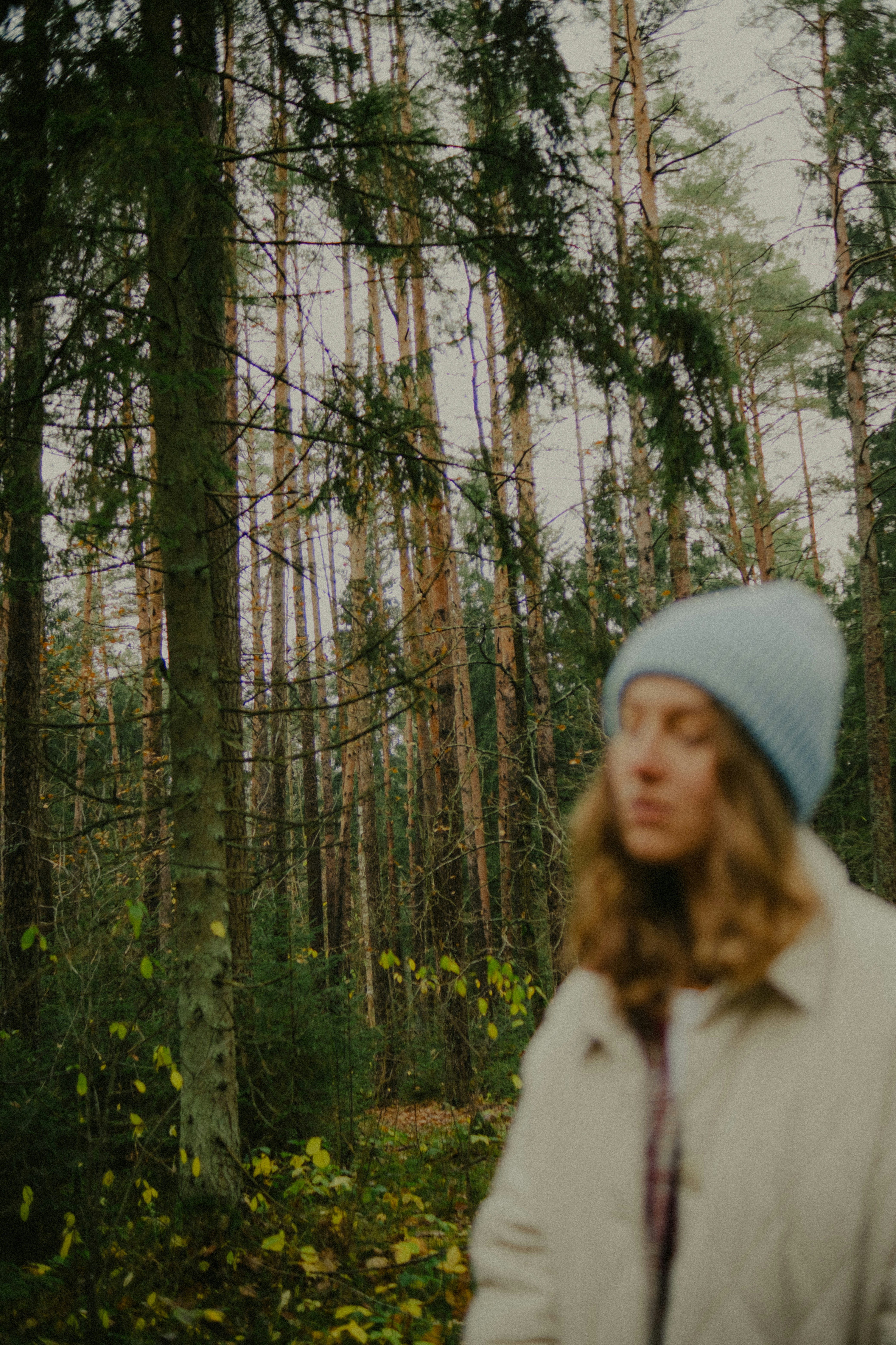 Woman wearing blue hat in autumn forest