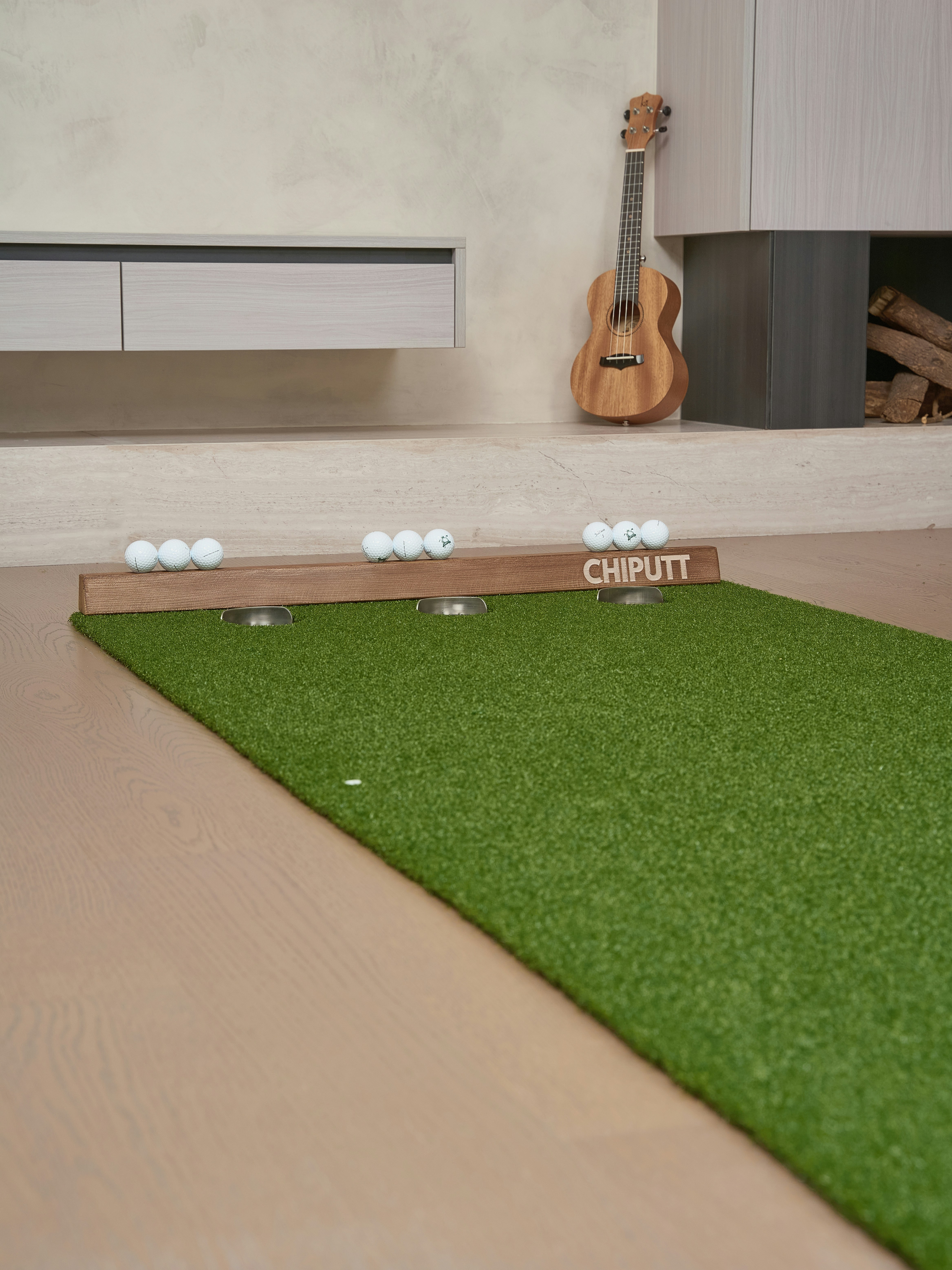 Indoor putting green with golf balls and ukulele