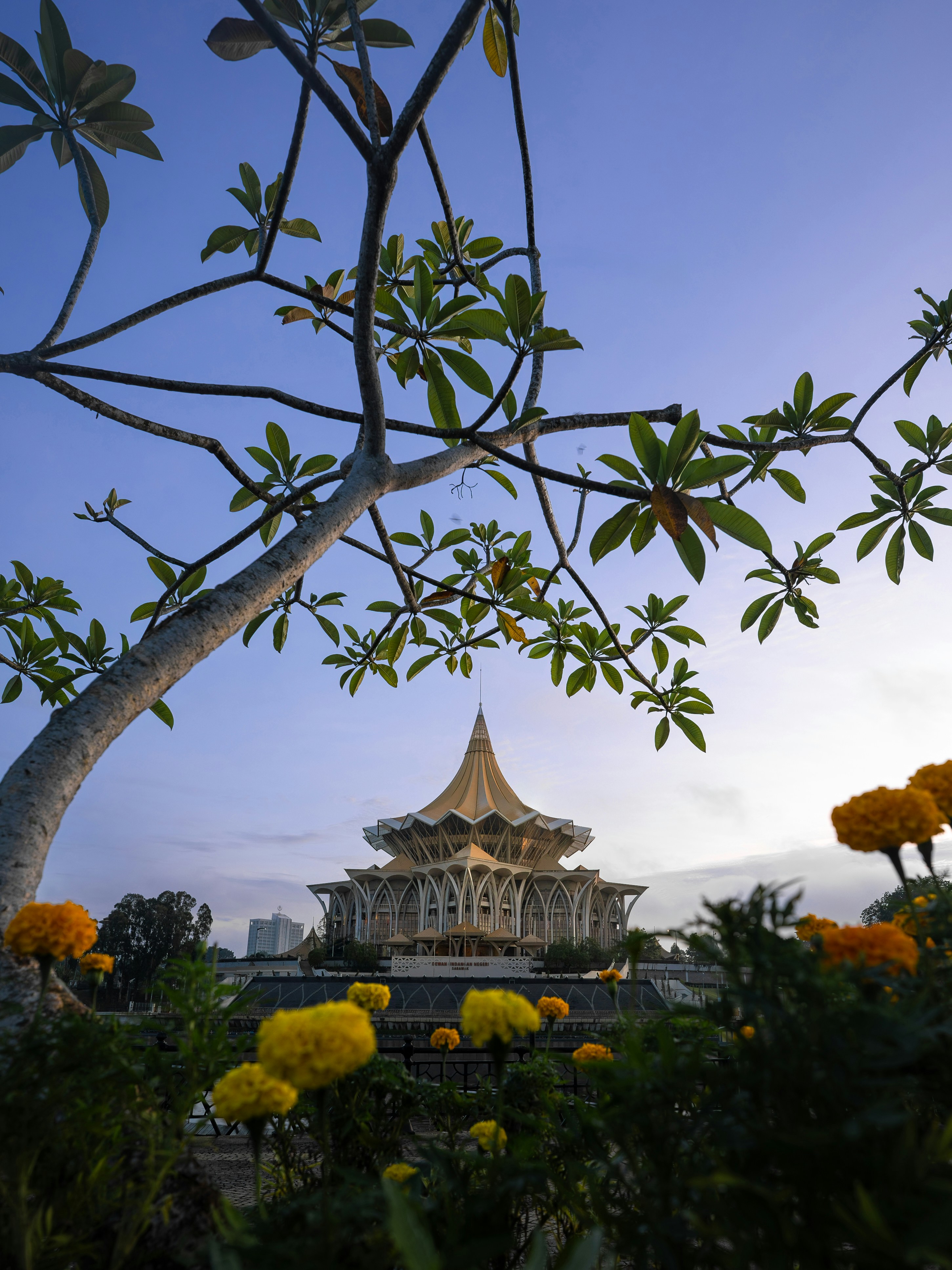 Ornate building with a distinctive roof surrounded by flowers.