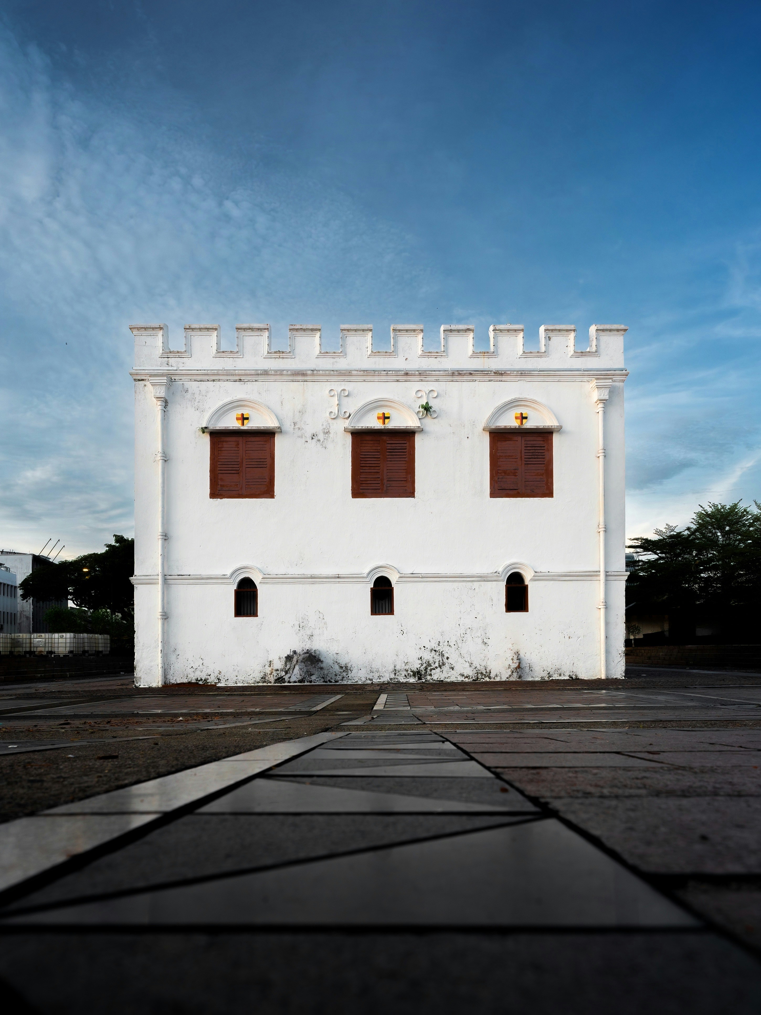 White fortress with crenellated roof against blue sky.