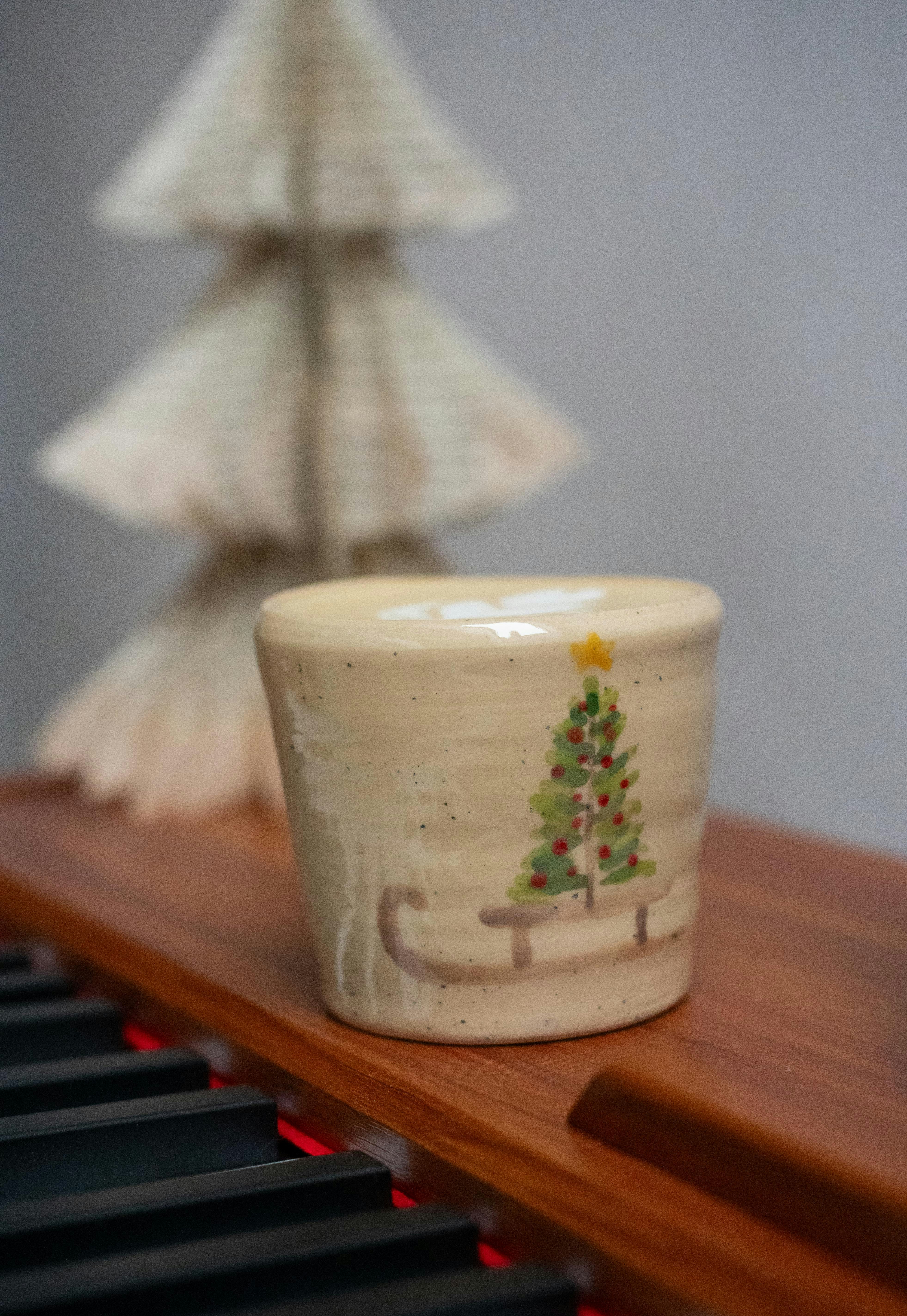 Ceramic mug with christmas tree design on wooden surface