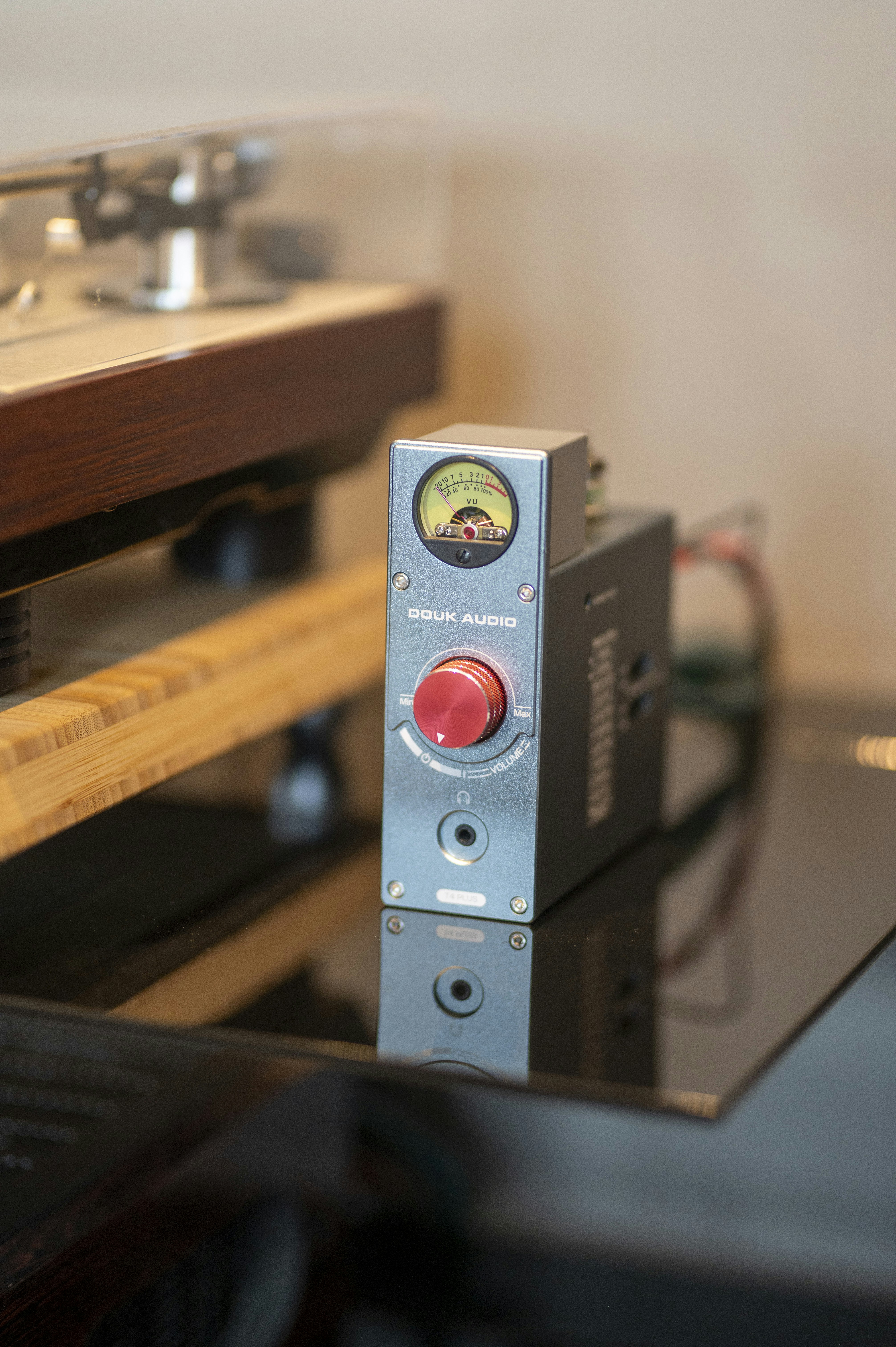 Silver audio amplifier with red knob and meter.