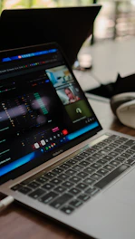 Laptop screen shows a video conference with multiple participants.