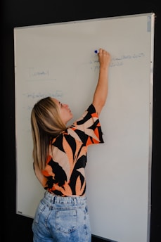 Woman writing on a whiteboard with a marker