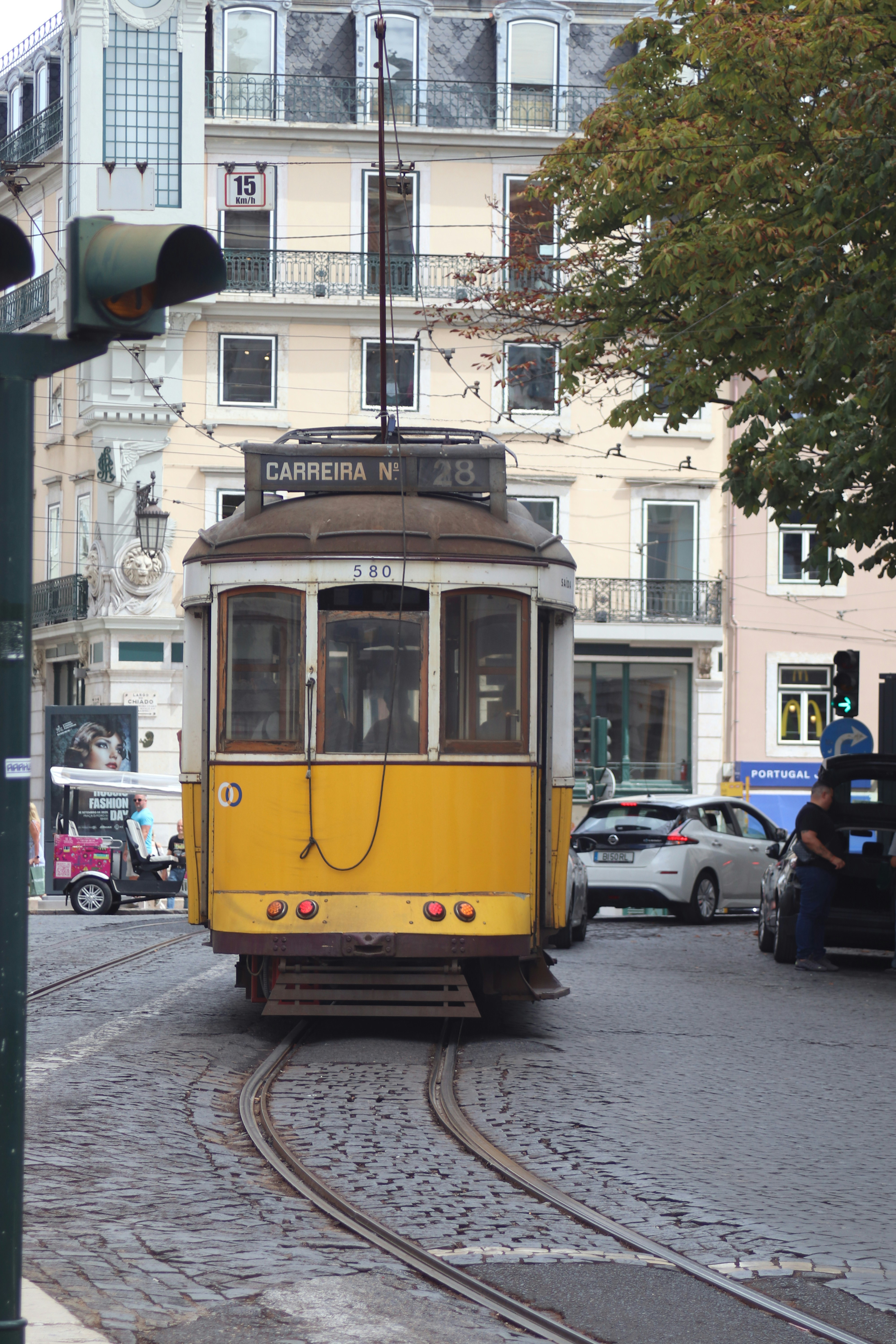 Yellow tram on cobblestone street in lisbon.