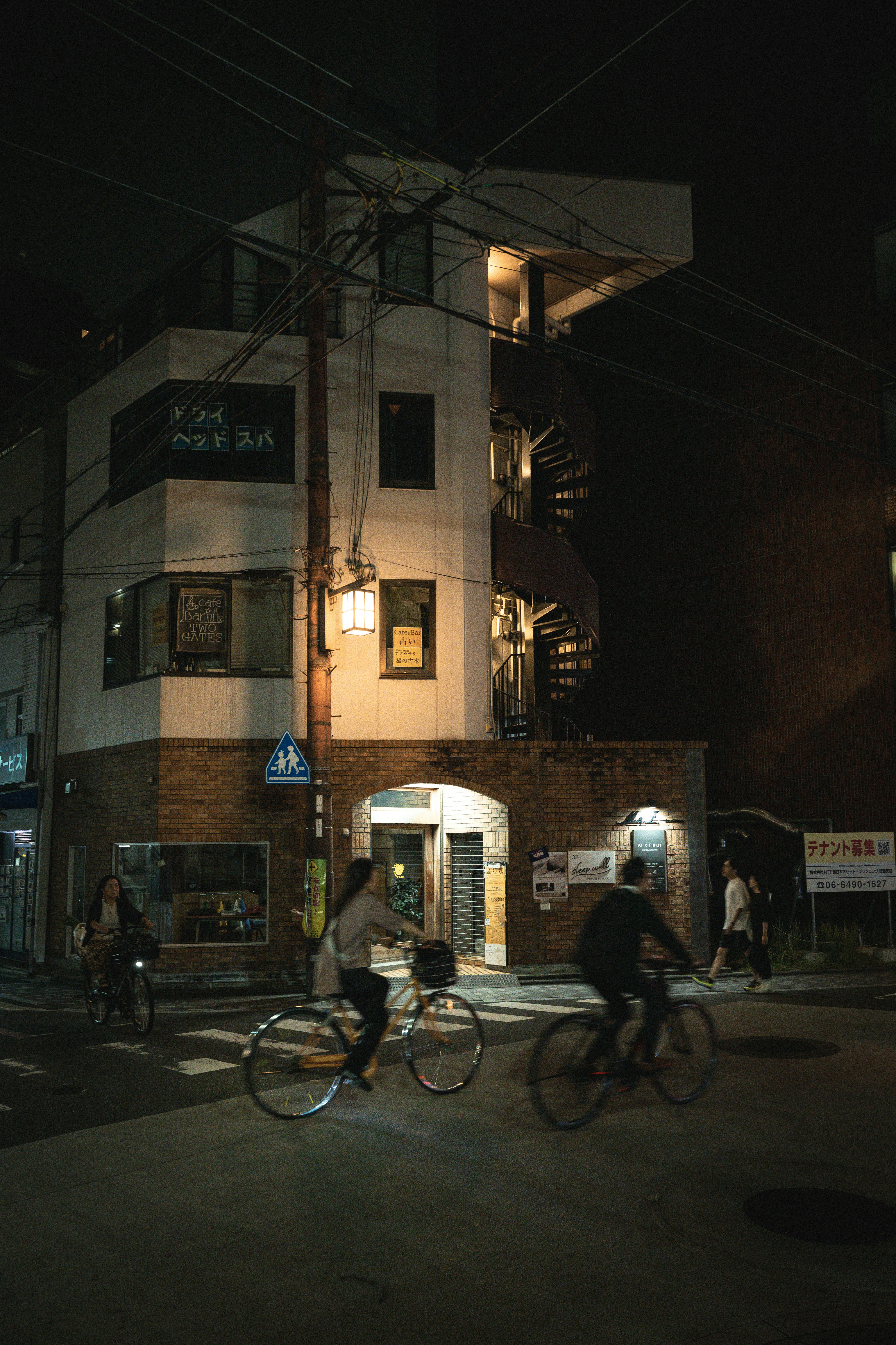 People cycling on a street at night.