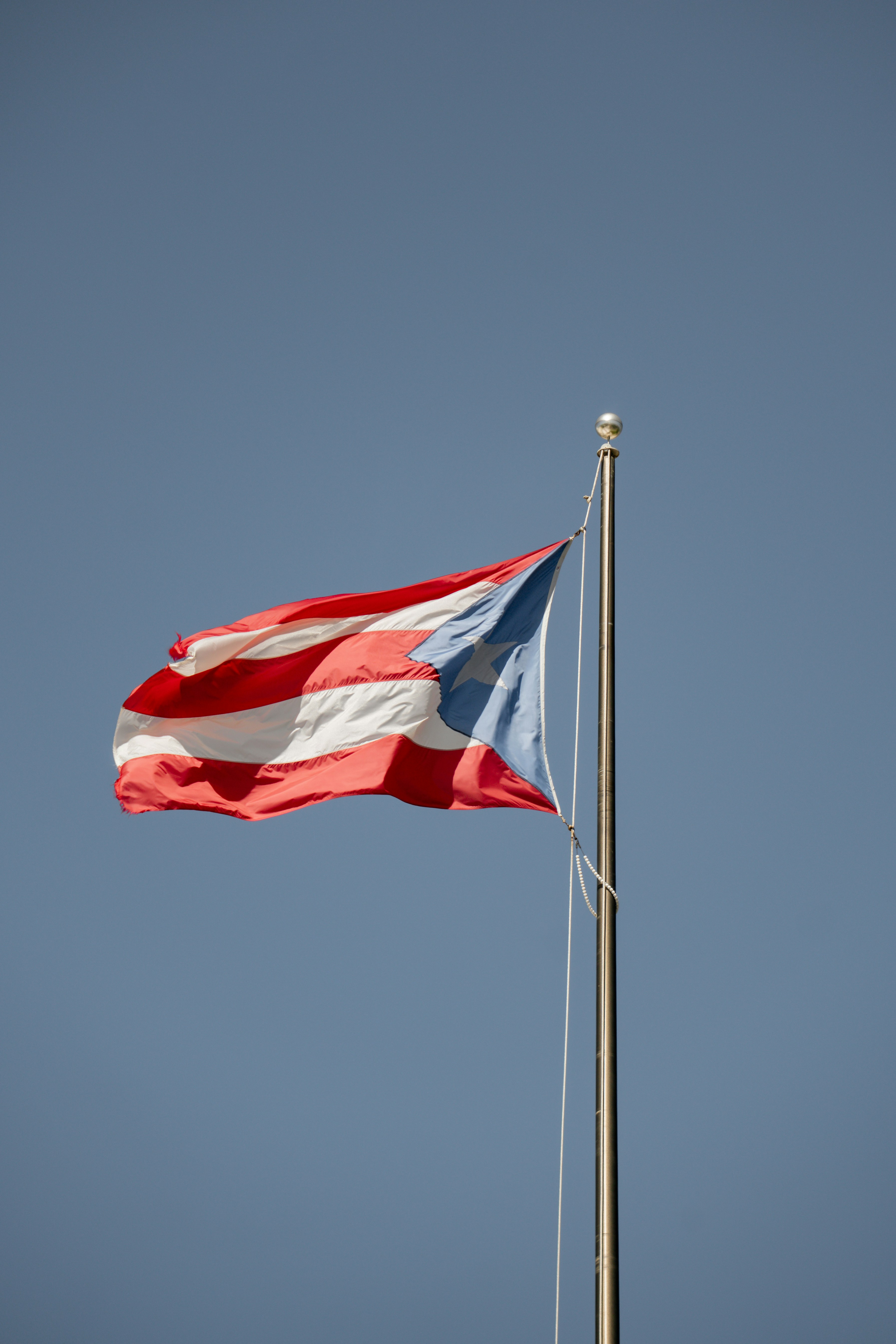 Puerto rican flag waving against a clear blue sky
