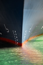 Bow of a large ship entering calm green water