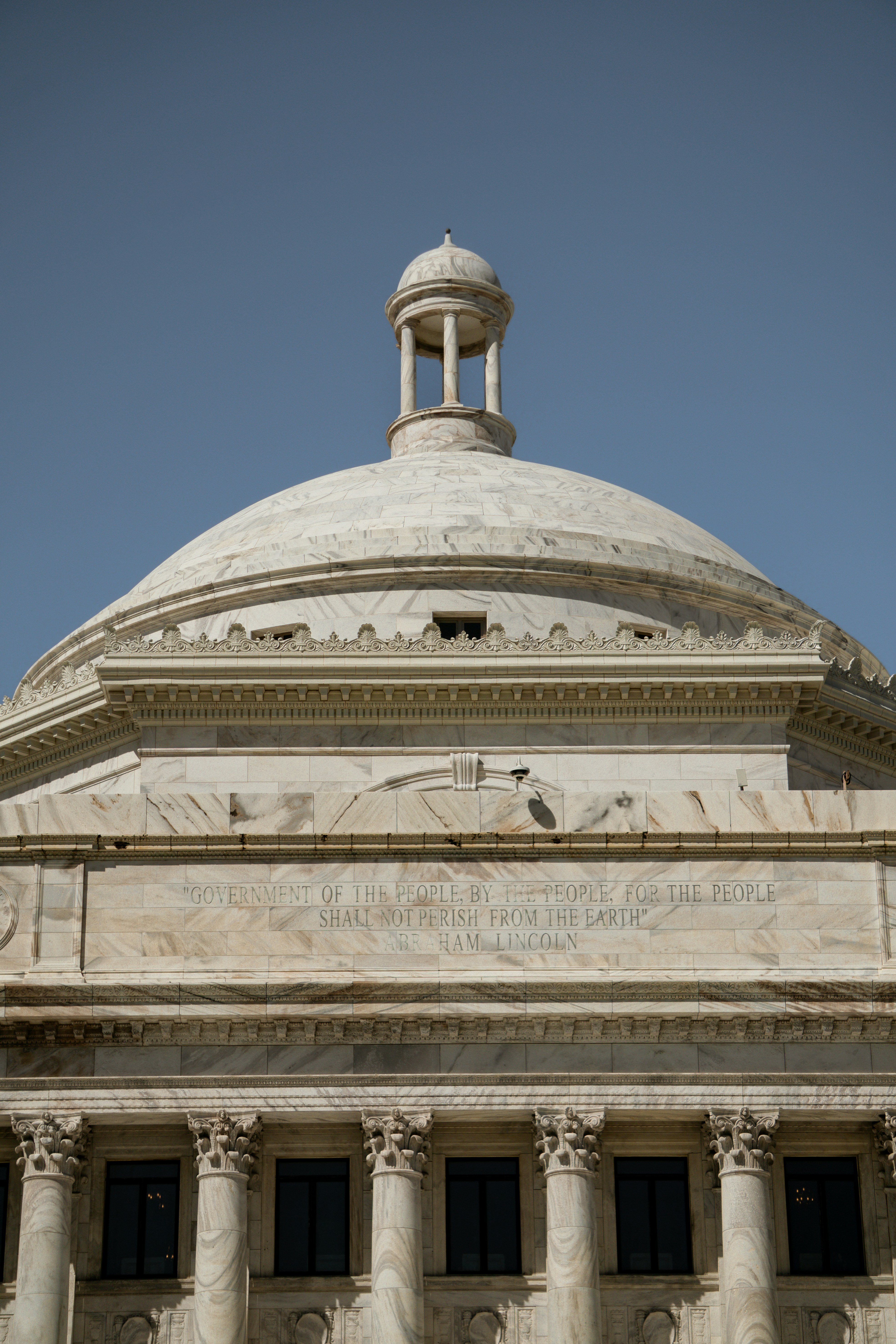 White marble dome building with columns and blue sky