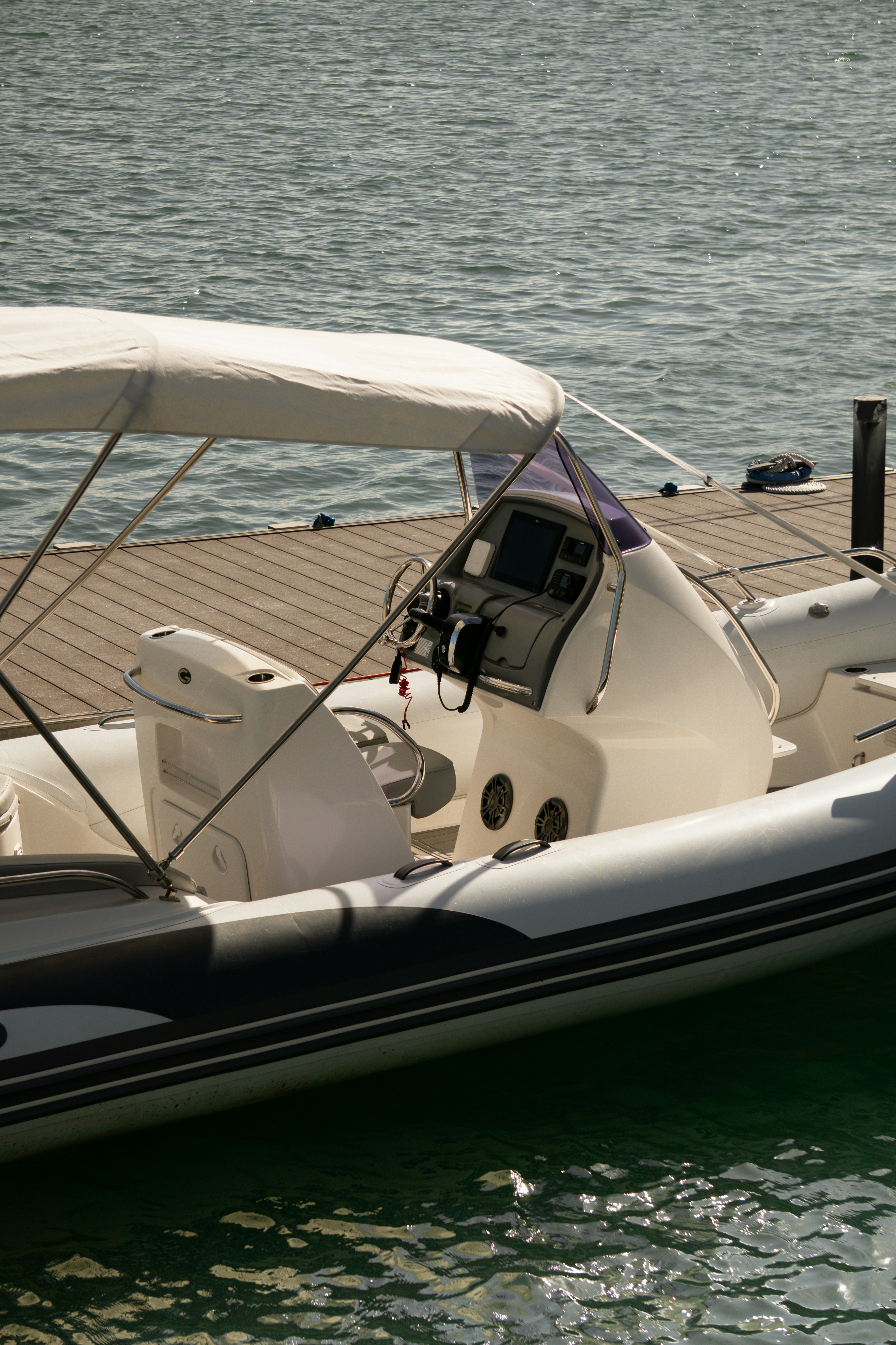 White inflatable boat docked at a wooden pier.