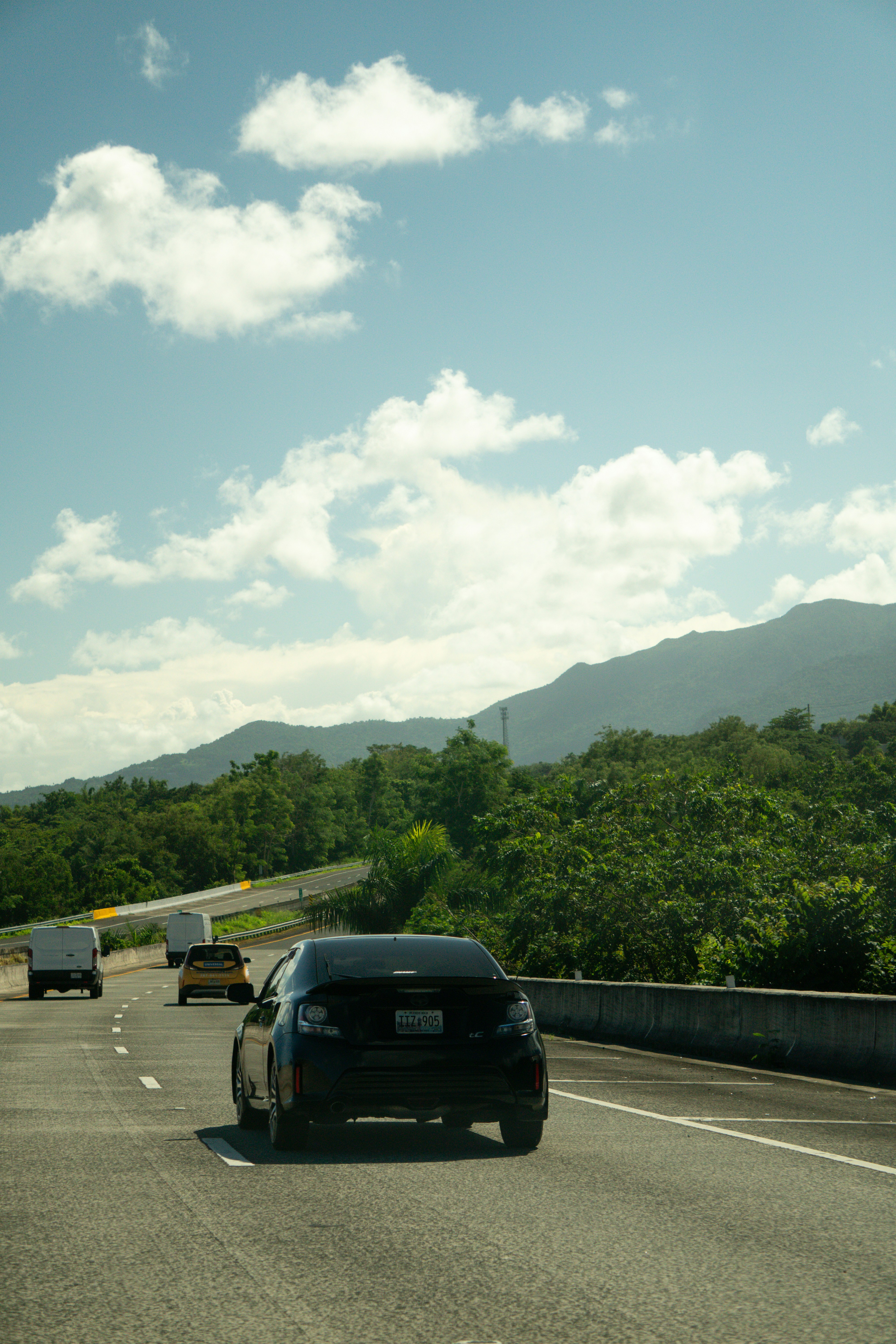 Cars driving on a highway with mountains in background