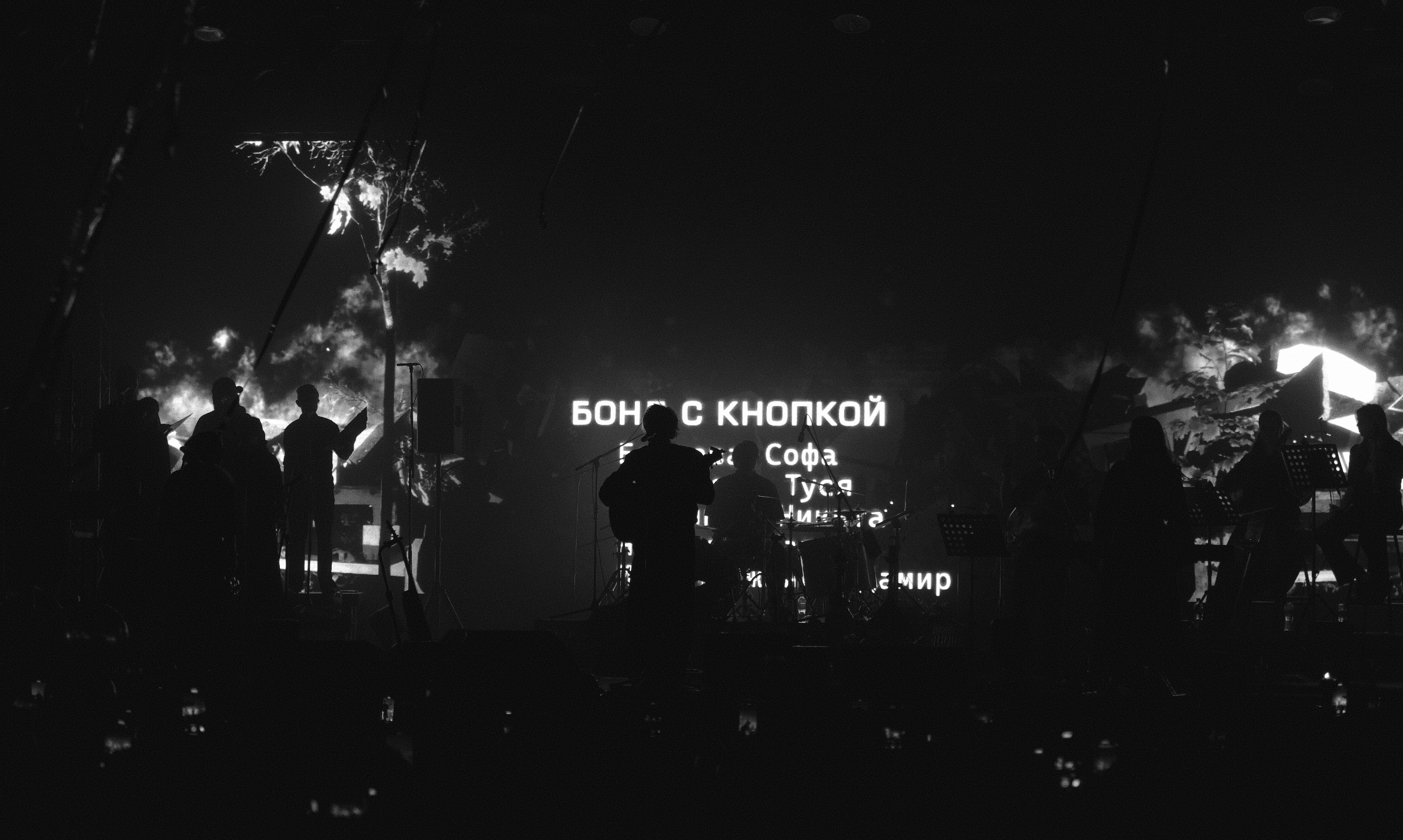 Silhouettes watch a projection with russian text