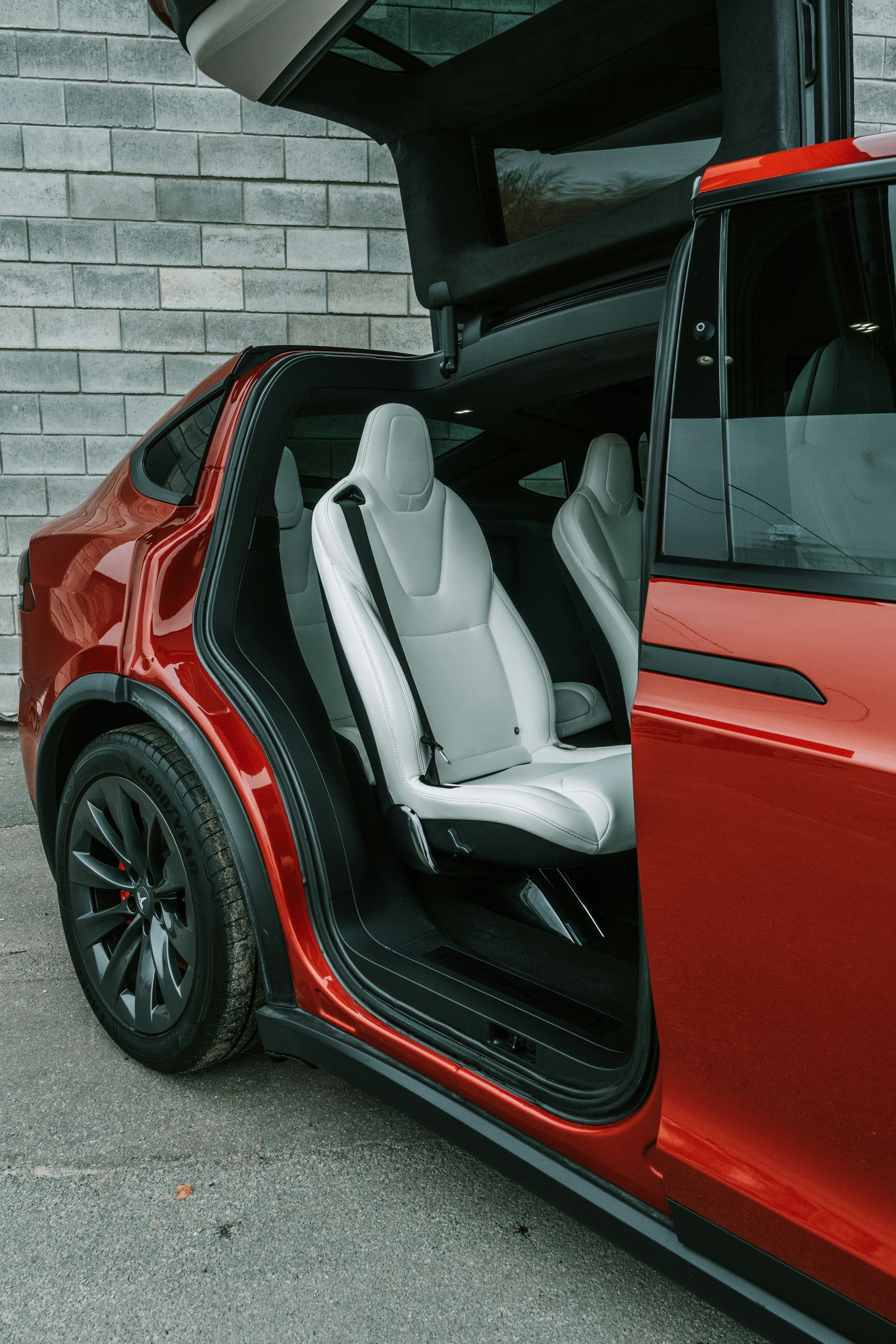 Red car with open doors and white interior