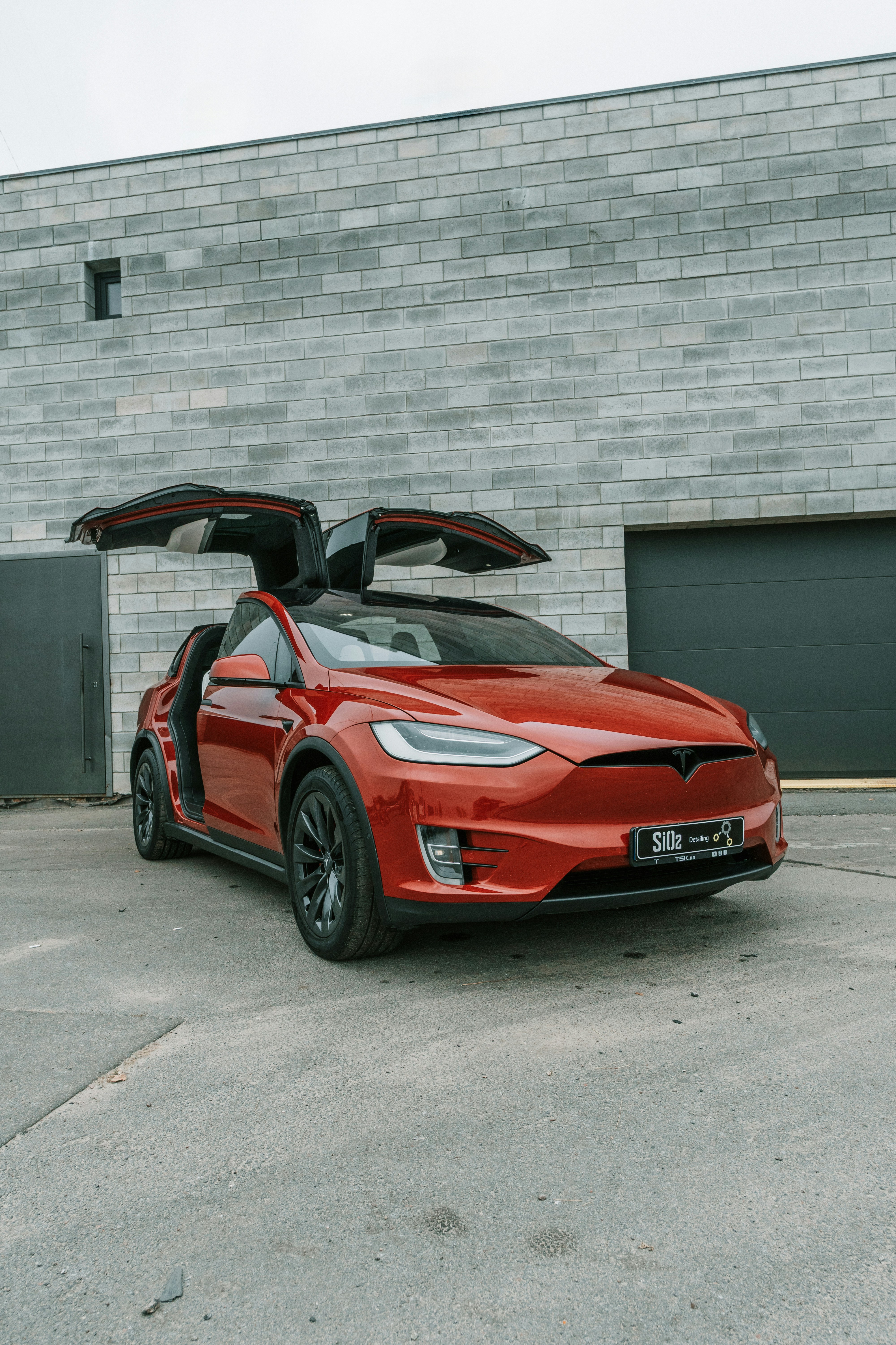 Red tesla model x with falcon wing doors open