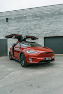 Red tesla model x with falcon wing doors open