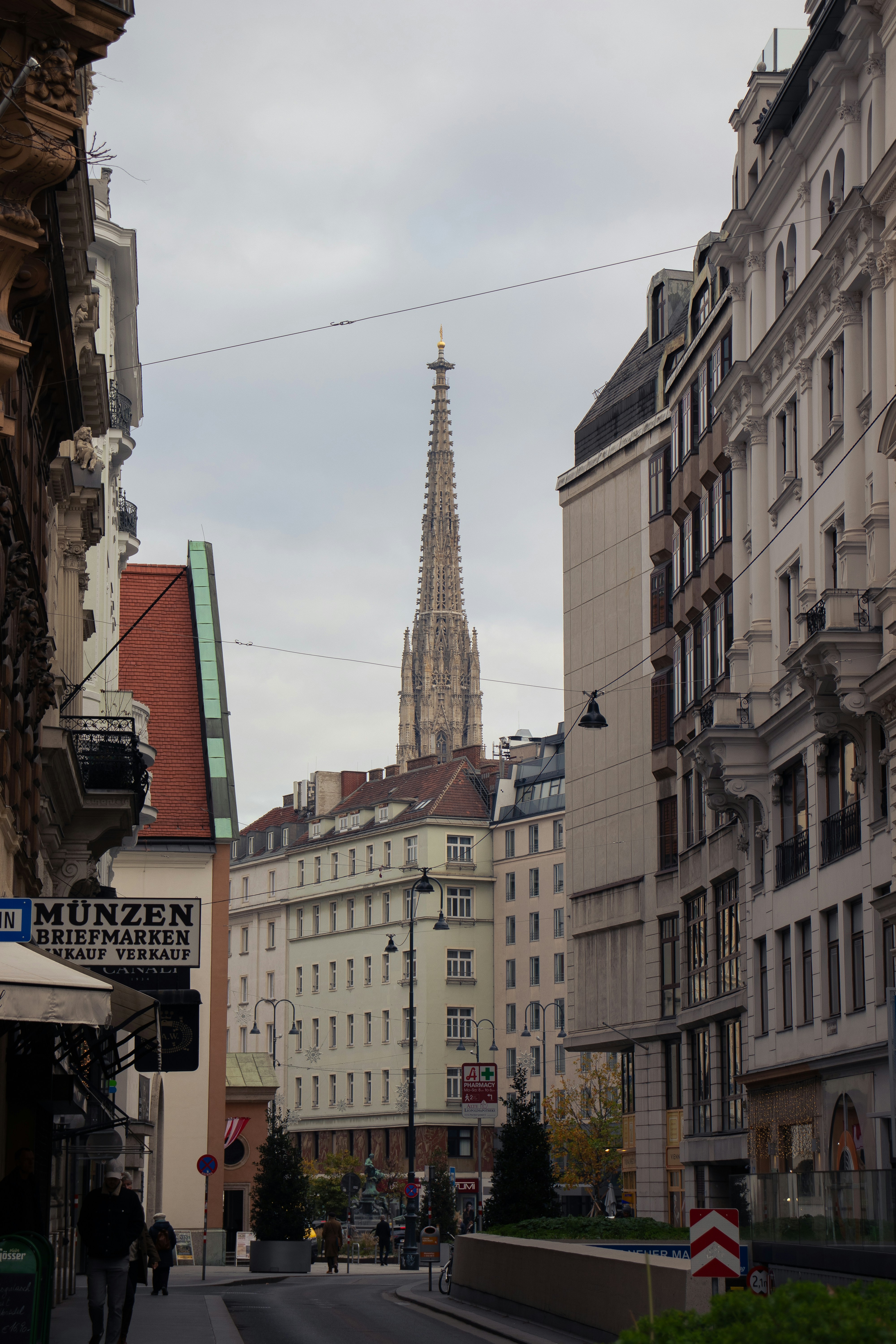 Tall spire rises above city buildings on cloudy day
