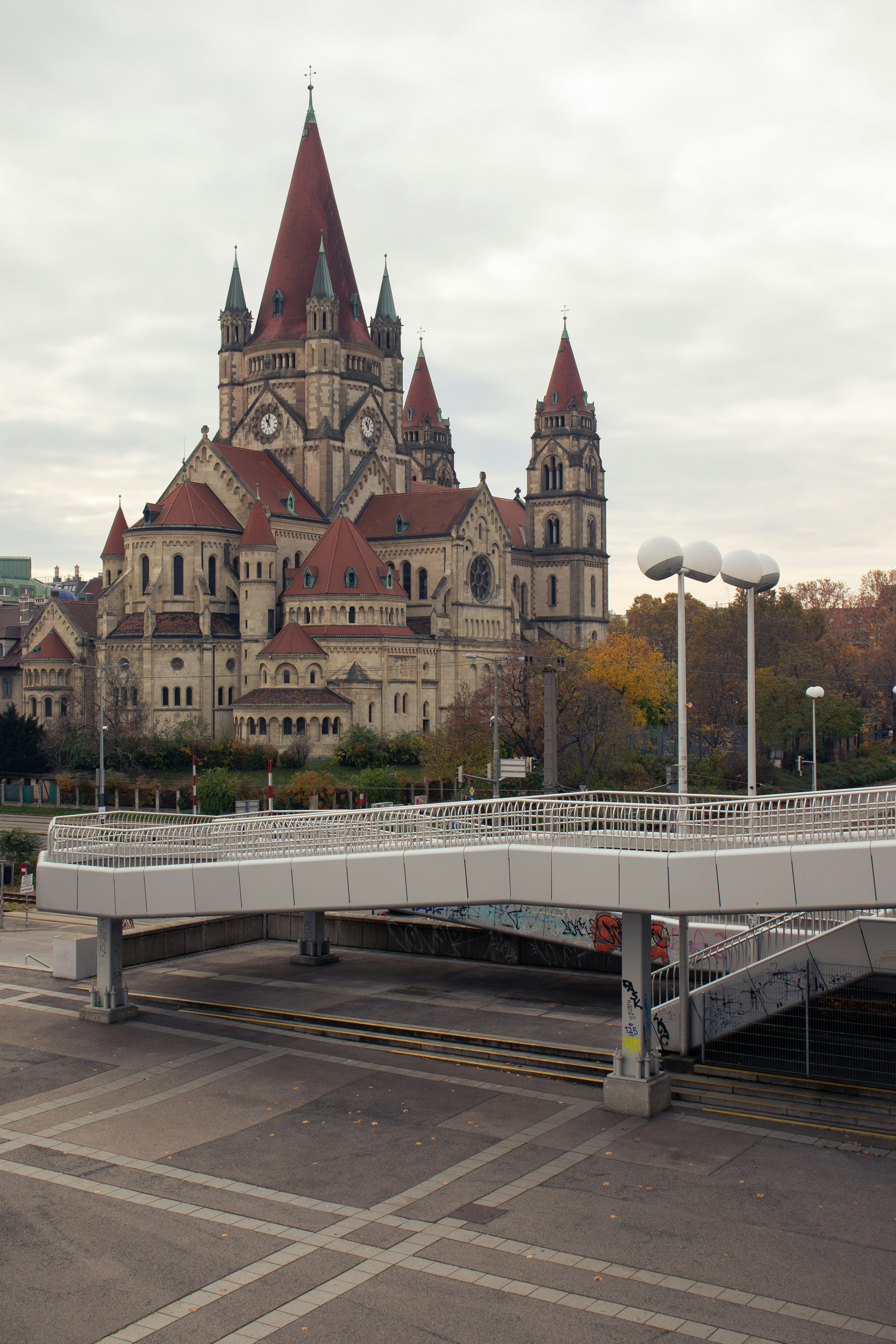 Historic church with red spires and pedestrian bridge