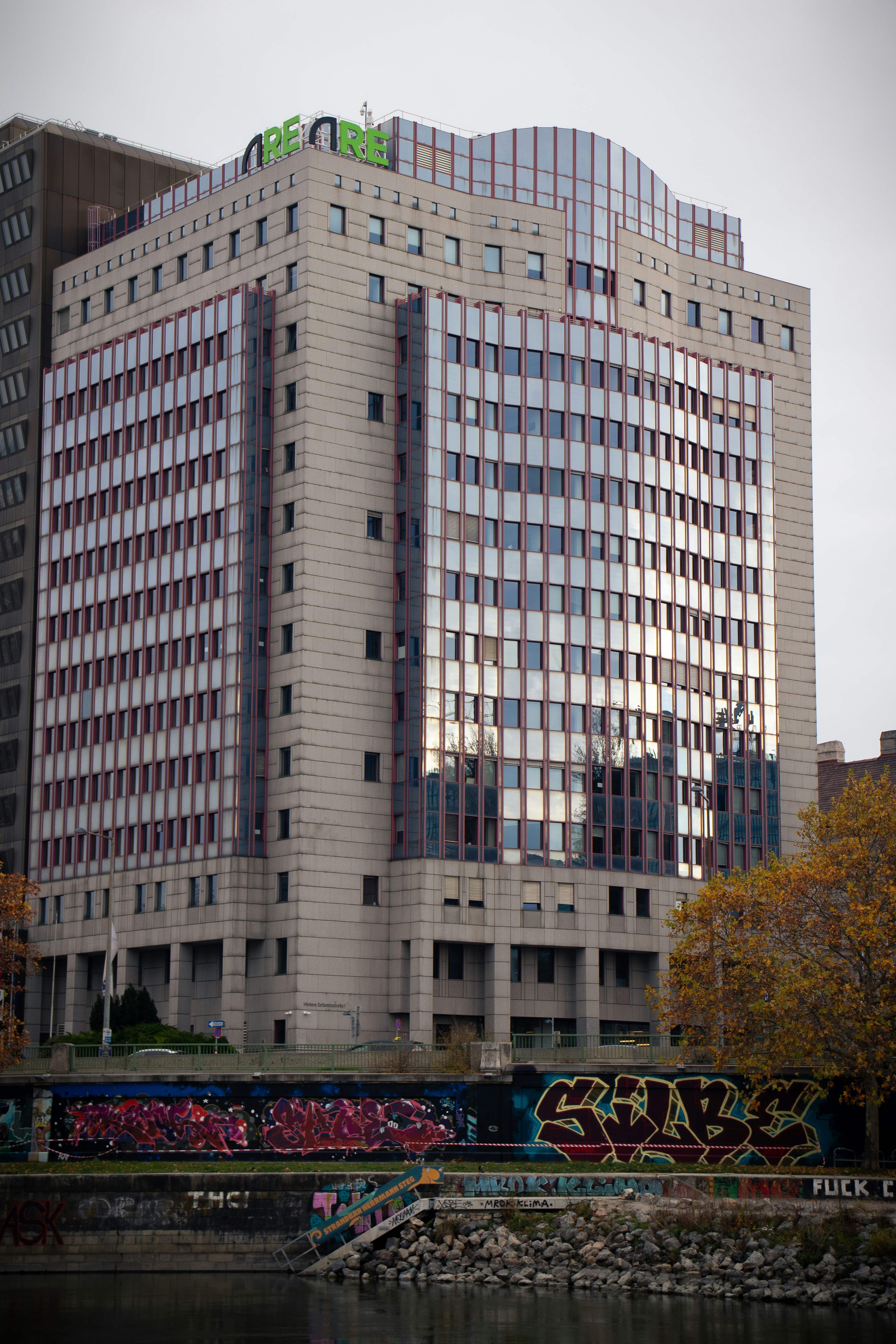 Modern office building with reflective windows and graffiti.