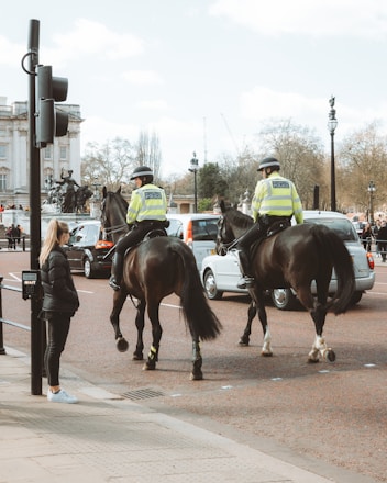 Two mounted police officers on horseback observing traffic