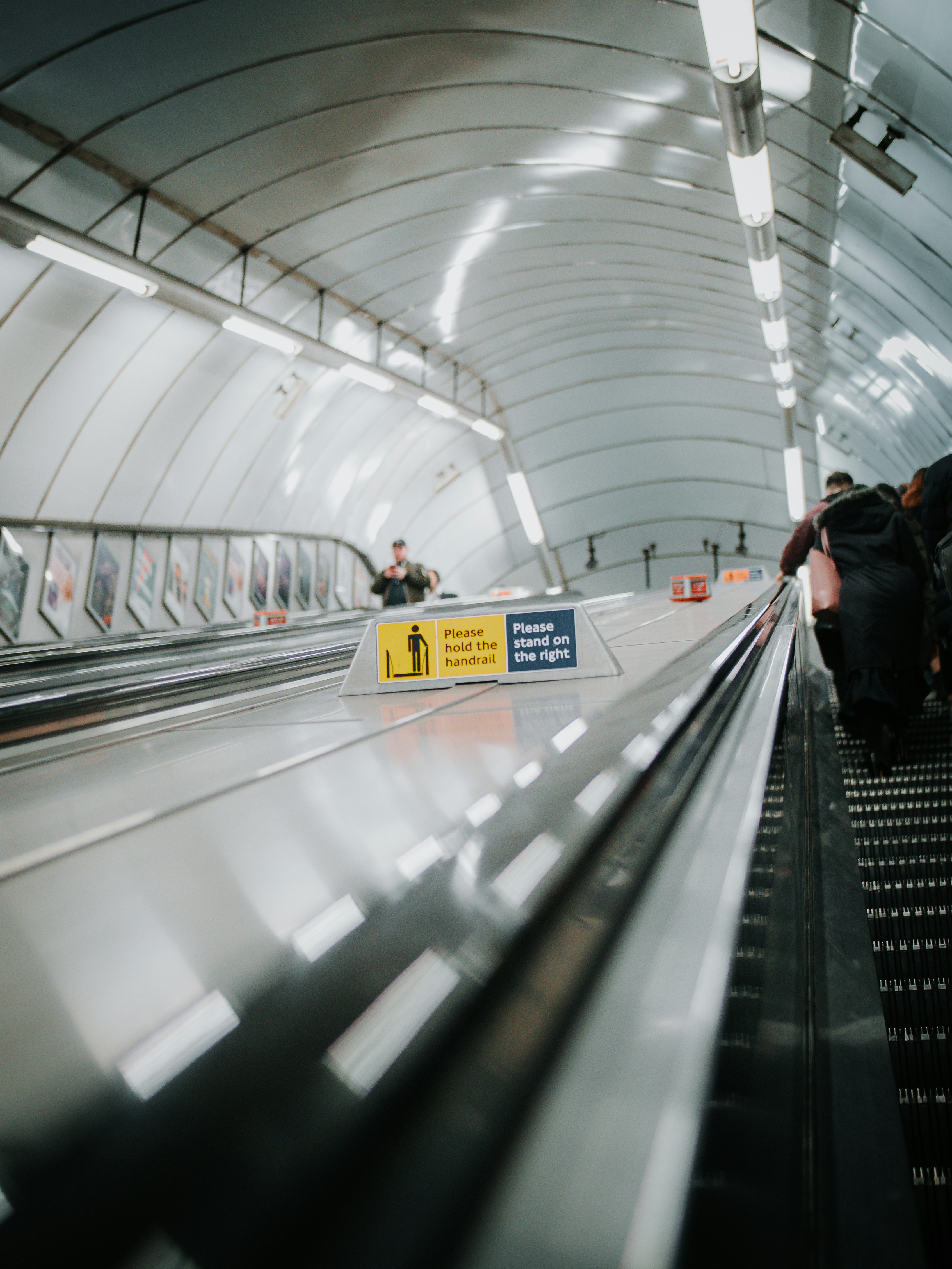People riding an escalator in a modern subway station.