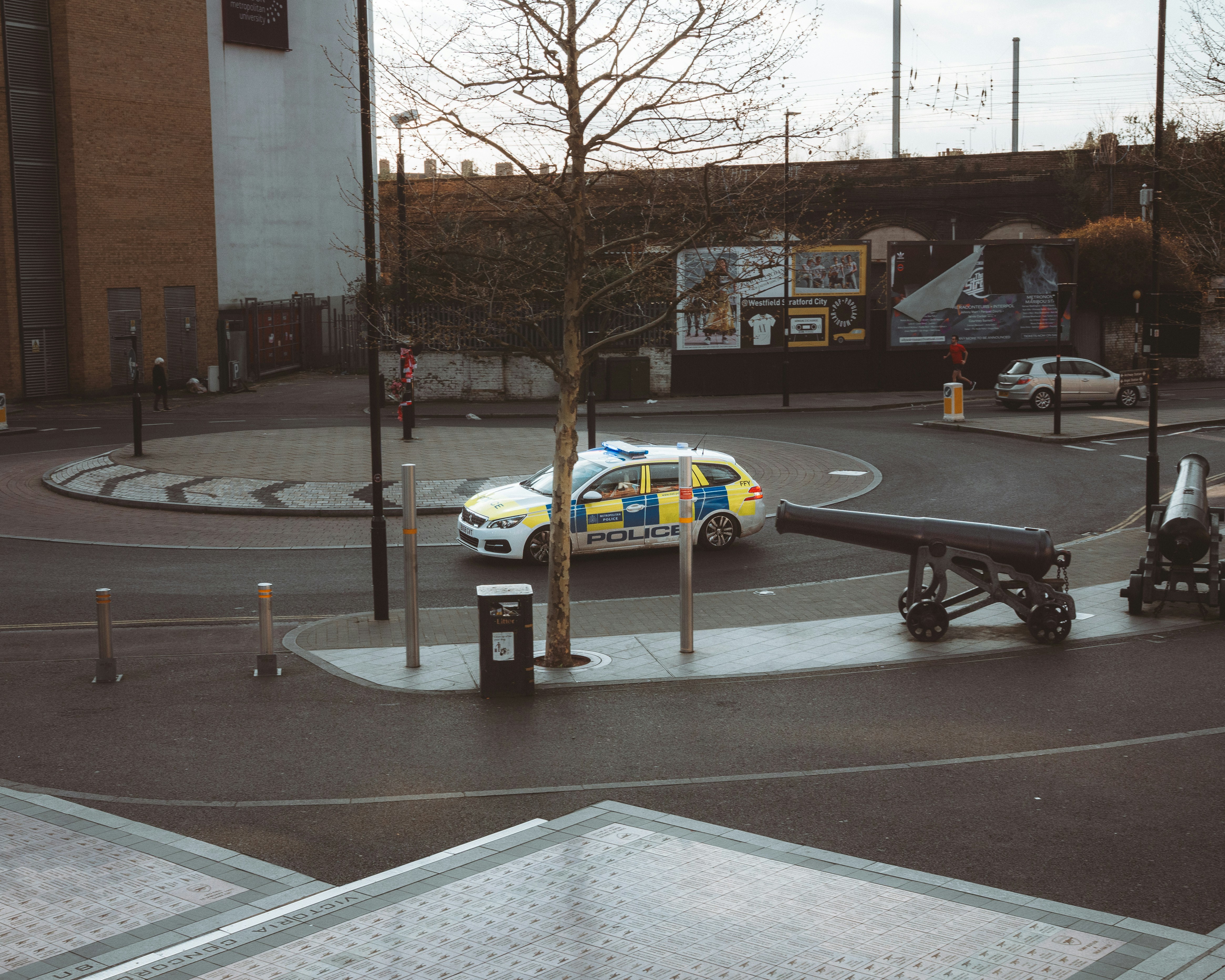 Police car driving around a roundabout with cannons.