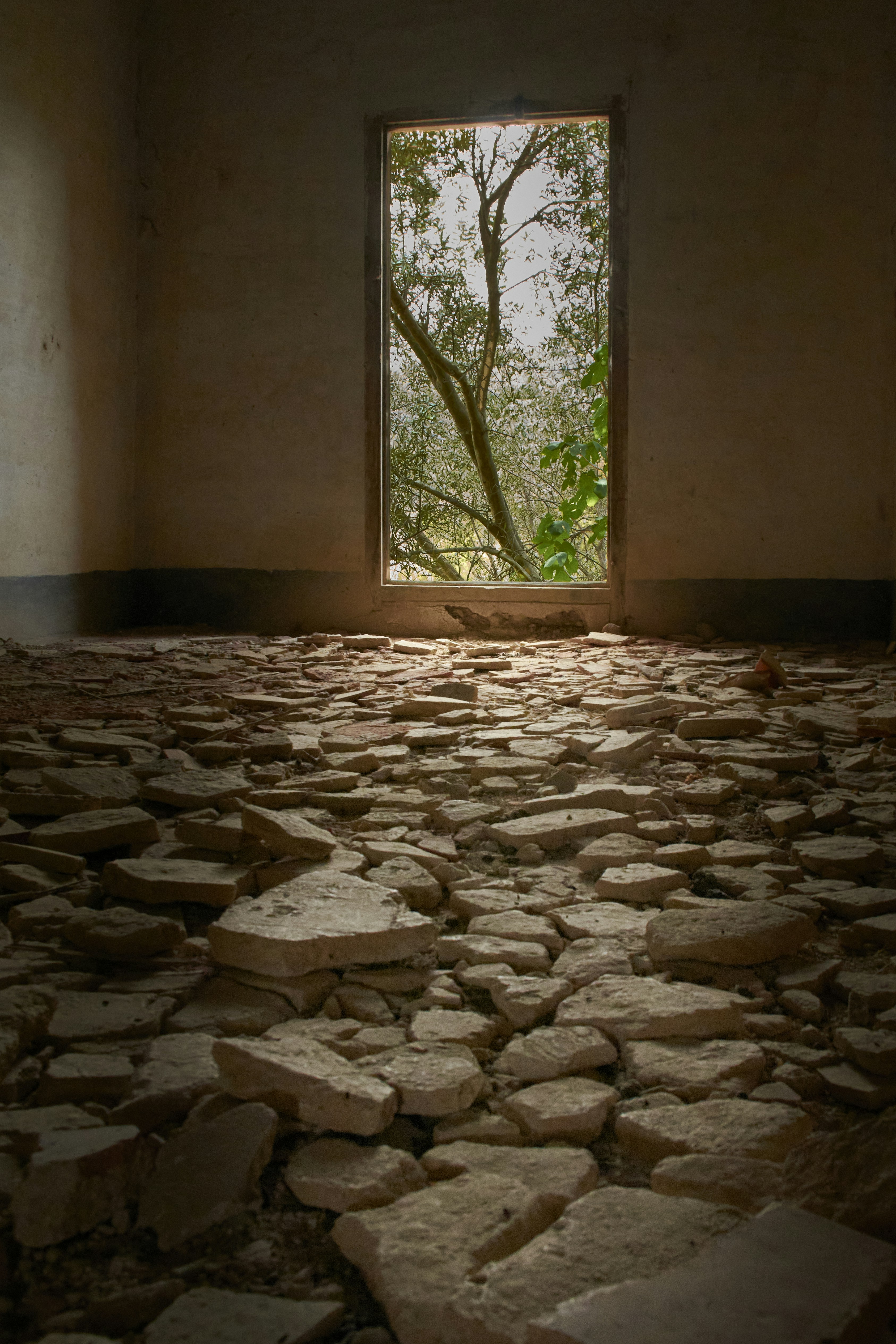 Abandoned room with debris-covered floor and open doorway.