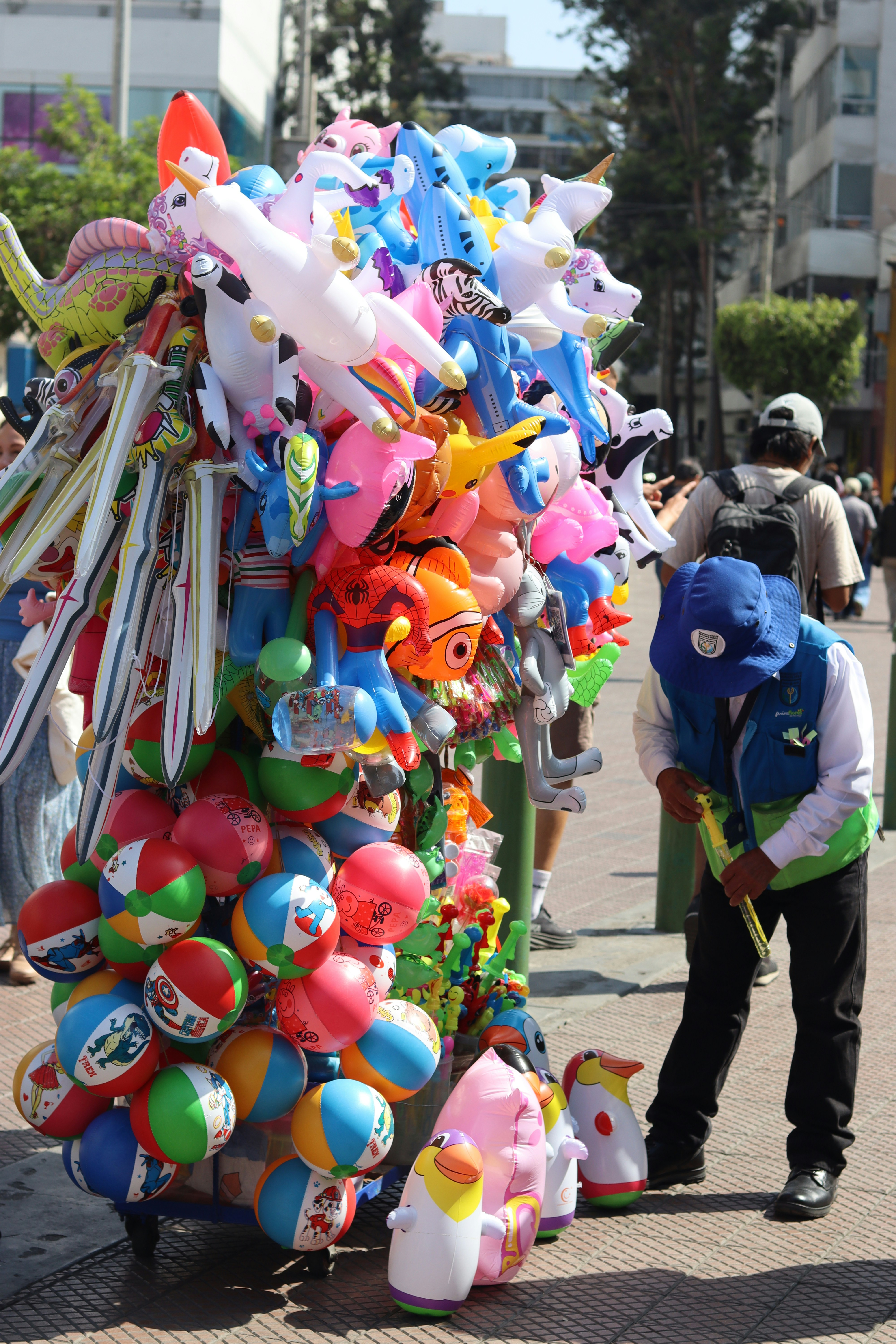Vendor sells colorful balloons and beach balls on street
