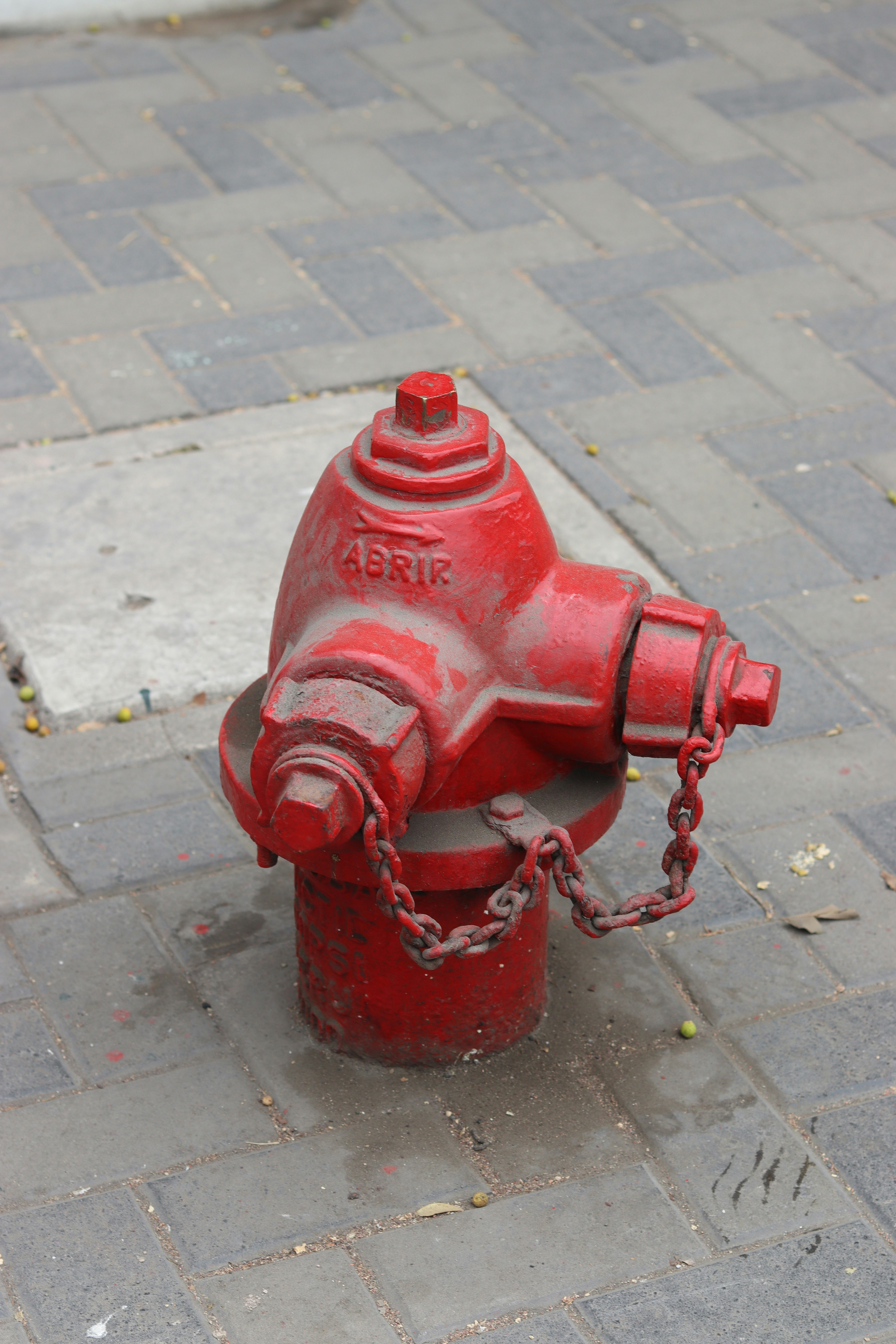 A red fire hydrant on a paved sidewalk.