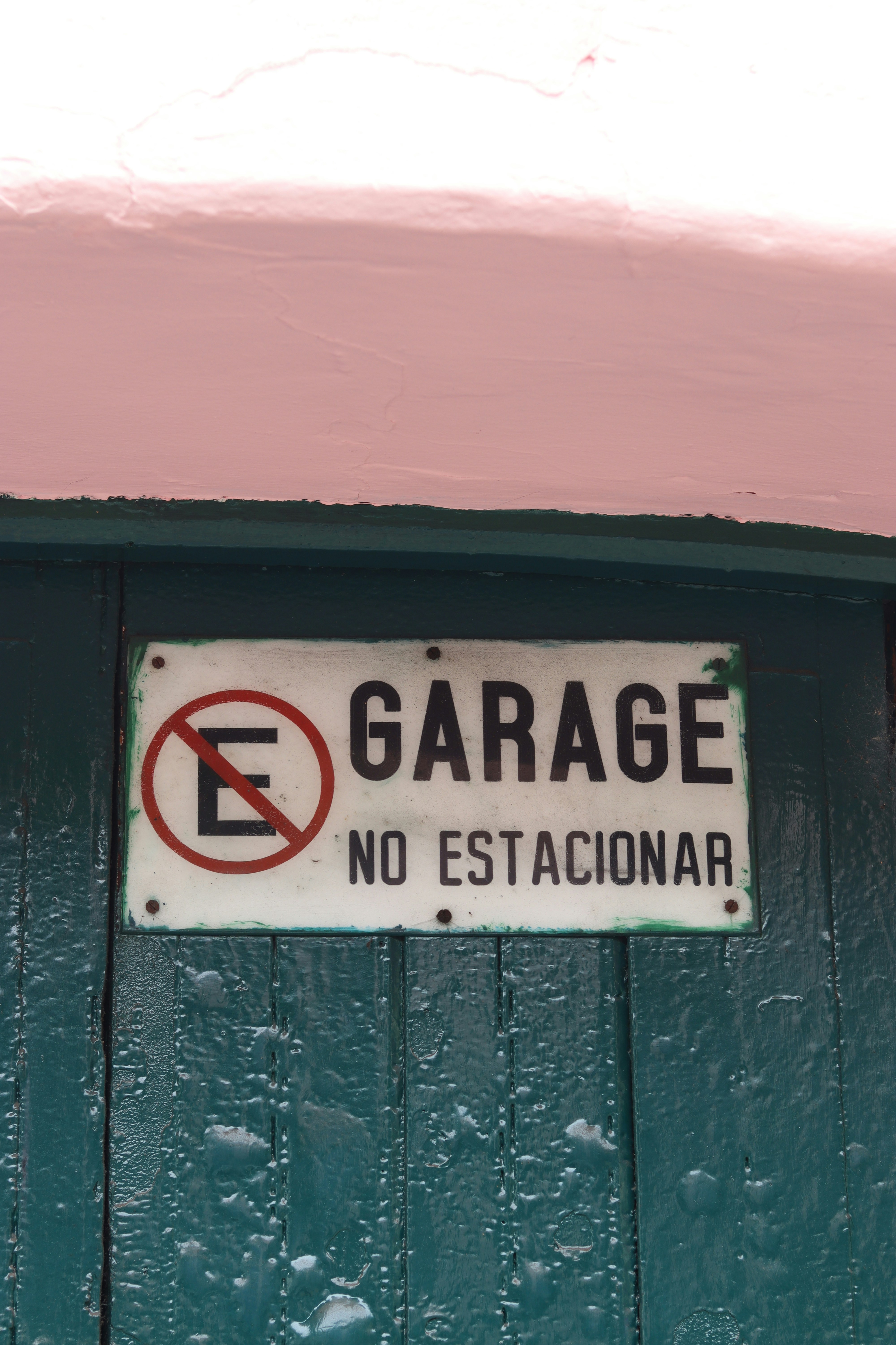 No parking sign on a green wooden door.