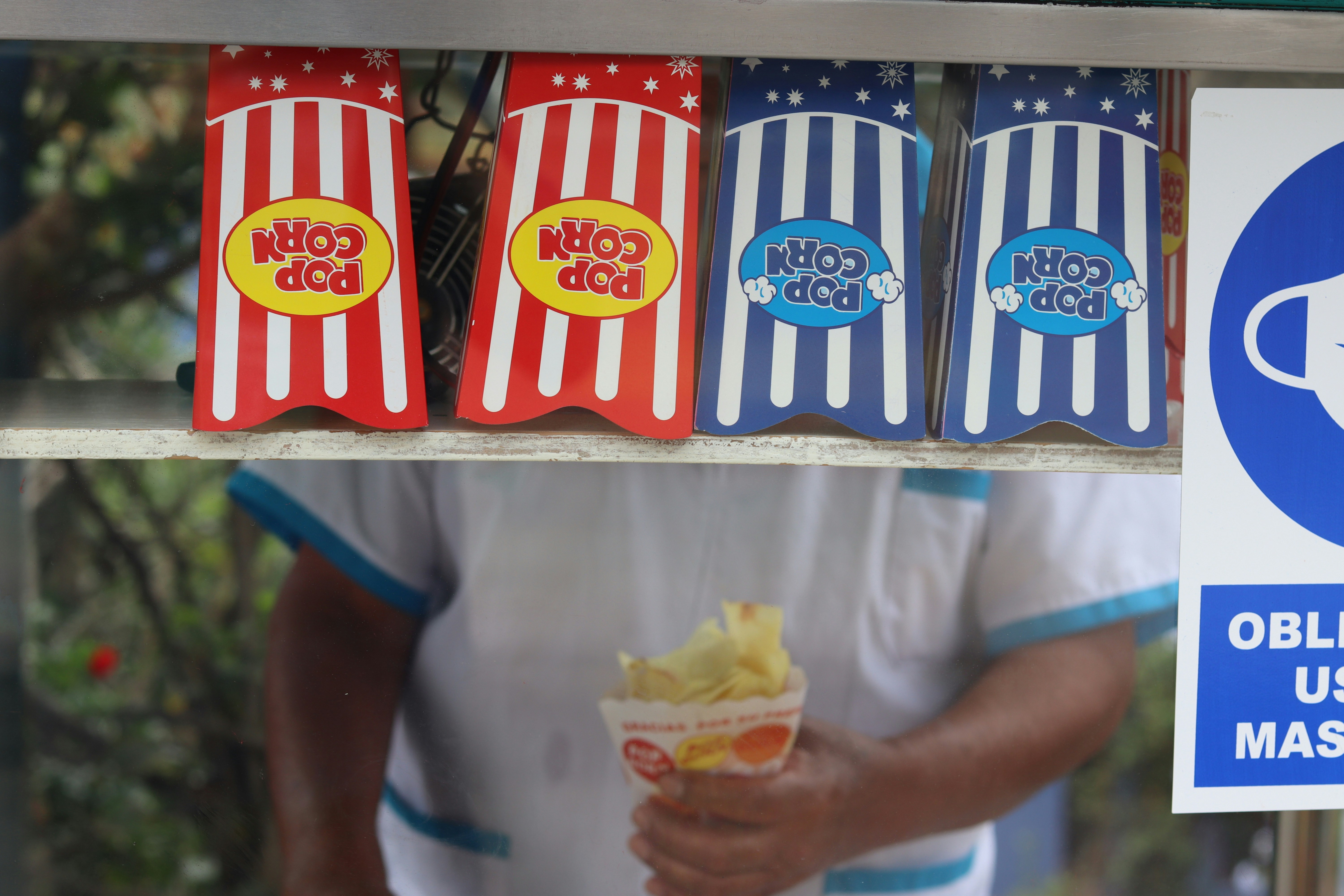 Popcorn bags and a hand holding popcorn
